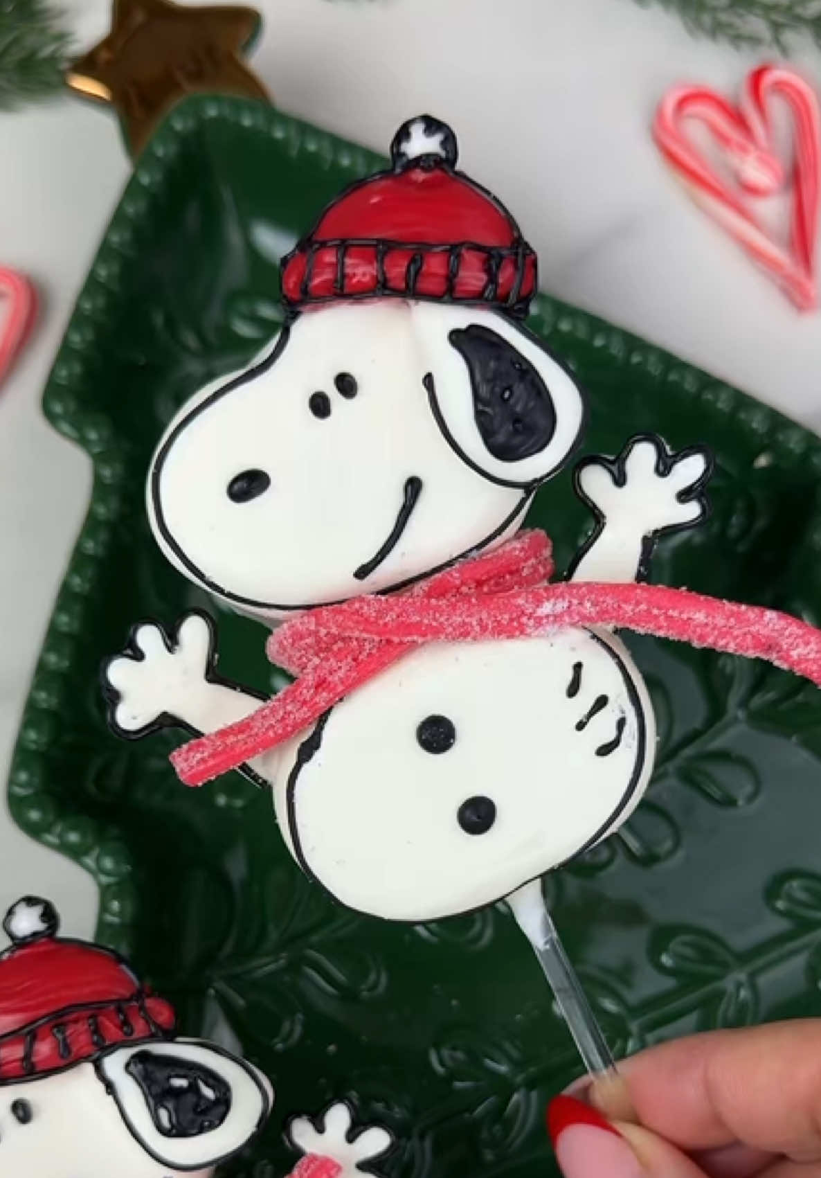 Snoopy snowman marshmallow pops! ☃️♥️ I dipped these in a 50/50 blend of @Stover & Company bright white sweet shoppe melting wafers and eleven o’one vanilla melting wafers. The hat is a red melting wafer that I cut with a round cutter. I piped the hands with chocolate on parchment paper. #marshmallows #marshmallow #marshmallowpops #chocolatecoveredmarshmallows #chocolatecoveredtreats #dippedtreats #snoopy #snoopychristmas #peanuts #peanutsgang #charliebrownchristmas #christmastreats #christmasbaking #christmasparty #christmaspartyideas #christmaspartyfood