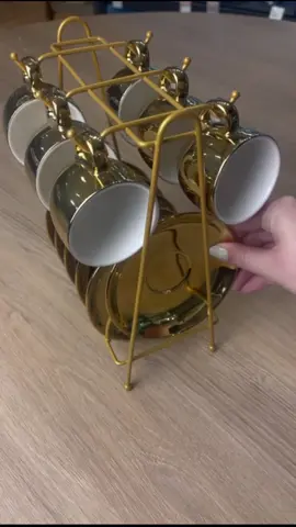 ☕ Conheça o Conjunto de 6 Xícaras de Café de Porcelana com Pires e Suporte - Linha Versa. Com acabamento dourado brilhante e interior branco, suas xícaras unem elegância e exclusividade, enquanto o suporte metálico oferece praticidade e um toque decorativo para sua mesa ou cozinha. Transforme sua hora do café em uma experiência única, com excelência Wolff. #Wolff130Anos #LinhaVersa #MesaPosta