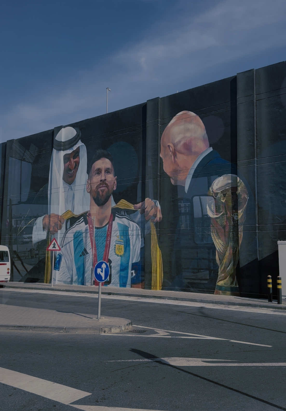 ‏An iconic moment from the land of the World Cup 🌍🇶🇦✨ A stunning mural featuring football legend Messi wearing the Qatari bisht during the historic Qatar 2022 World Cup 🏆. A blend of culture and sports captured in one masterpiece ❤️⚽️ #Qatar2022 #Messi #StreetArt #Doha #Football” . “لحظة خالدة من أرض المونديال 🌍🇶🇦✨ لوحة فنية تجمع بين أسطورة كرة القدم ميسي والبشت القطري في أجواء كأس العالم التاريخي في قطر 2022 🏆. الثقافة والرياضة في صورة واحدة تُجسد نجاح البطولة وكرم الضيافة القطرية ❤️⚽️ #قطر2022 #ميسي #فن_الجداريات #الدوحة #كرة_القدم”