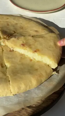 Осетинский пирог с картошкой и сыром 🧀🥔 Как вы уже поняли, главный принцип осетинского пирога мало теста, много начинки, а не наоборот. Считается, что чем тоньше тесто, тем искуснее повар.  Начинкой осетинского пирога также может быть мясо, зелень, овощи. На 1 пирог: Тесто: 300 г муки 7 г быстродействующих дрожжей щепотка соли 1/2 ч. л. сахар 30 мл растительного масла 180 мл воды Начинка: 280 г сыра сулугуни 300г отварного картофеля перец молотый 50г сливочного масла 1. Смешиваем в миске все ингредиенты для теста. Руками или с помощью стационарного миксера замешиваем гладкий однородный шарик теста. Смазываем стенки миски растительным масло. Кладём тесто, накрываем пищевой плёнкой миску и убираем в тёплое место подниматься на 1 час. 2. Натираем сыр, отварной картофель разминаем толкушкой и смешиваем с сыром. Добавляем соль и перец по вкусу, хорошо перемешиваем, формируем шар. 3. Присыпаем рабочую поверхность мукой, выкладываем тесто и ладонями делаем из него блин толщиной примерно 2 см. В центр кладём сырно-картофельную начинку. Диаметр блина должен быть чуть больше диаметра начинки. Края блина собираем и защипываем в центре. Затем переворачиваем швом вниз и расправляем ладонями начинку по всей площади пирога. В центре сверху пальцем делаем отверстие, чтобы воздух мог выходит из пирога. 4. Выпекаем на максимальной температуре духовки 15-18 мин. 5. Пока пирог горячий, смазываем его сливочным маслом и делим на 8 кусочков. #mood #pie #cake #cheese 