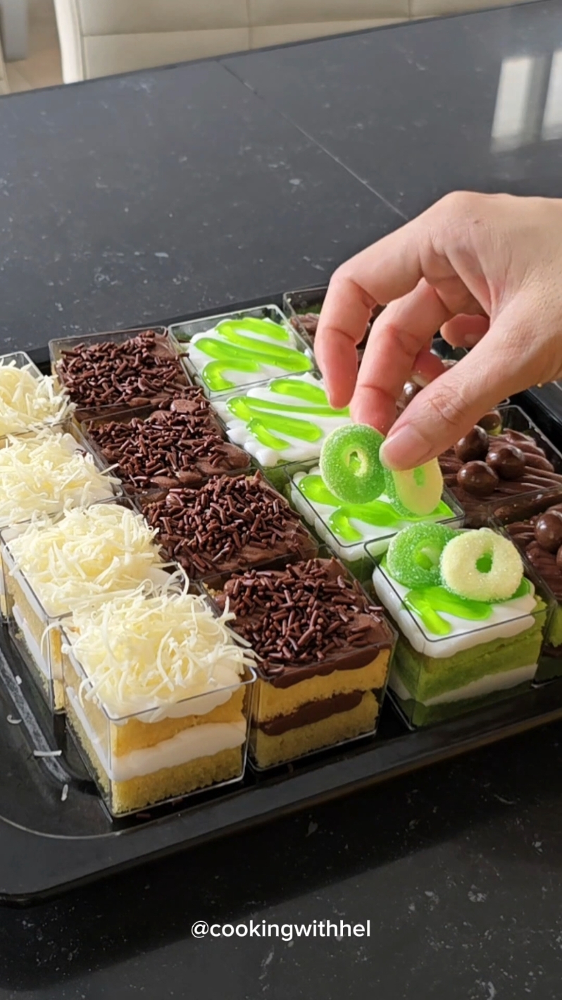 Mini cake Thailand seliweran mulu, cake potongan mini dengan aneka topping warna warni. Seharusnya dibungkus plastik ya, tapi saya pakai mini cup supaya lebih praktis. Cake yang dipakai bisa pakai sponge cake atau chiffon cake, atau resep mana yang teman² suka ya.  Mini cake Thailand by @CookingwithHel   Loyang 9x20 cm 2 pcs Hasil 20 cup Bahan: - telur 5 butir - emulsifier SP / ovalet / TBM ¾ sdt - gula 110 gr - terigu protein sedang / rendah 110 gr - susu bubuk 20 gr - pasta vanilla 1 sdt - butter/ margarin leleh 125 gr (suhu ruang) - pasta pandan ½ sdt Bahan cream - cream coklat: whipped cream bubuk rasa coklat + air es 100 ml - cream vanila : whipped cream original + air es 100 ml Topping bebas ya - keju parut - meses - selai - chicchoc - yupi - biskuit oven suhu 175°C sekitar 25 menitan. oven sudah dipanaskan sebelumnya Cara buat bisa dilihat di video. #minicakethailand #minicake