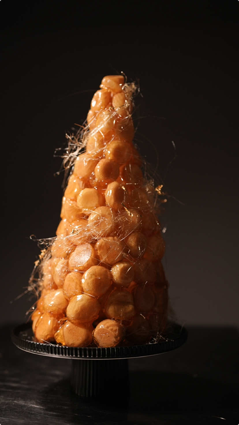 Ready to taste my big croquembouche? #croqeumbouche #newyears #donutdaddy Start the new year with a bang! A croquembouche. Housemate light and tasty choux pastry, Crunchy caramelised toffee coating and filled with a coffee pastry cream to start the new years off with a kick. Thin streams Caramel around the tower and gold leaf for decoration. Full recipe will be in my subscriber group this week.  #desserttime #nye #celebration #cooking 