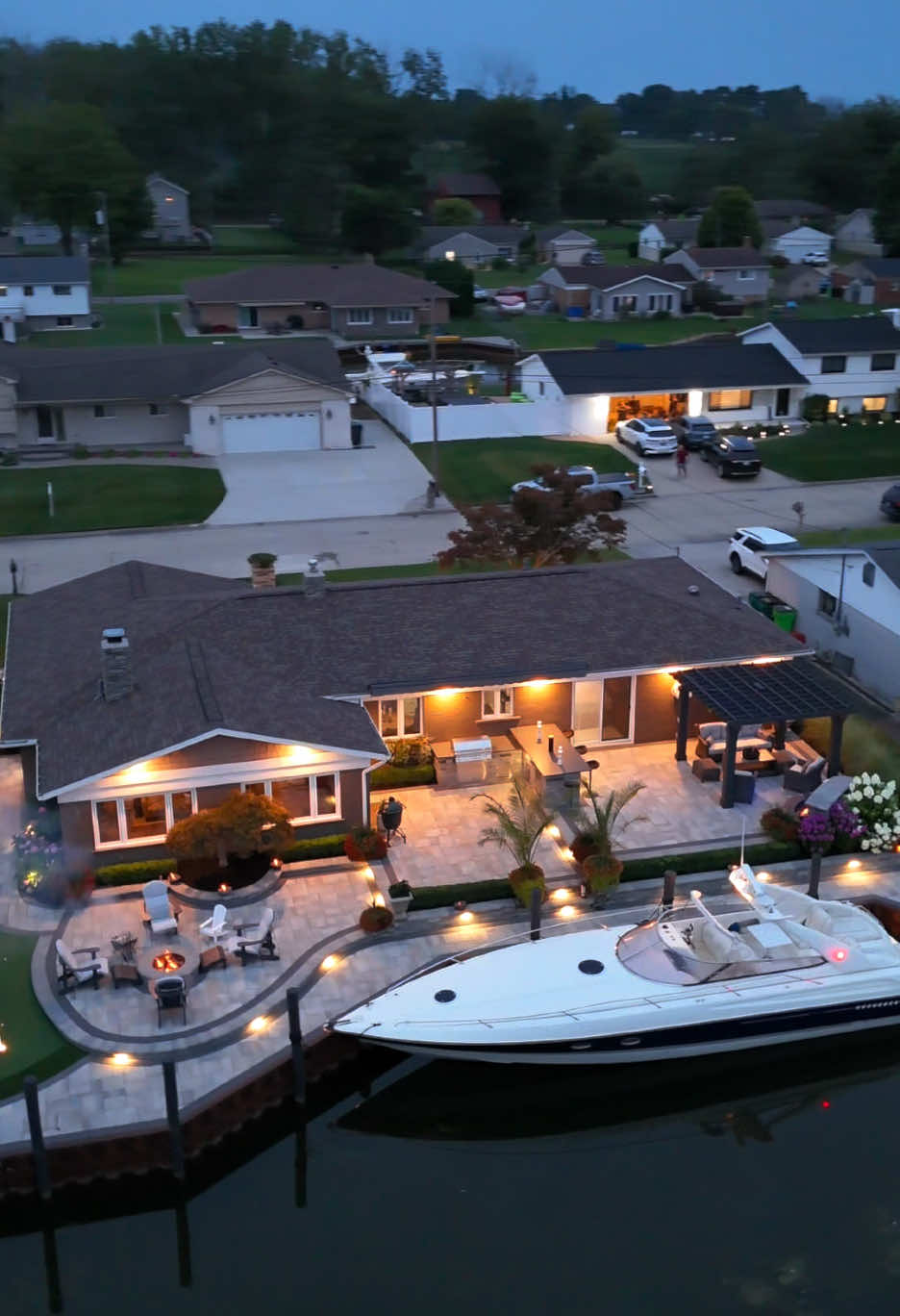 I would have never guessed the back looked like THIS… 😲🔥 A canal-side oasis with a boat dock, cozy fire pit, putting green, and grilling/bar area. @AntonelliLandscapePoolSpa can turn any backyard into the ultimate hangout spot, no matter the size. Who’s ready for a backyard upgrade this summer? #luxury #backyard #luxurylifestyle #outdoor #landscapes 