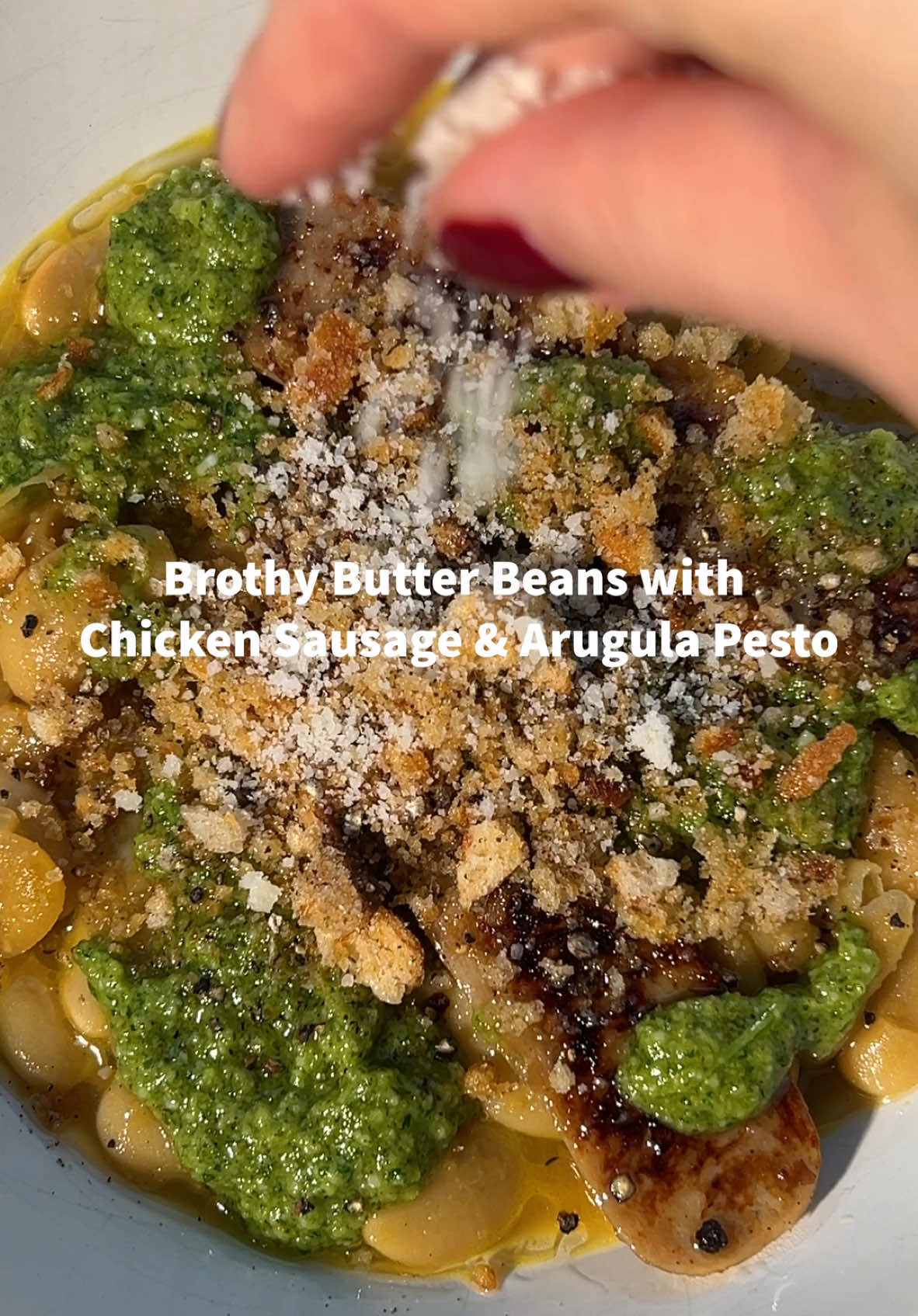 Keeping tonight's dinner cozy with brothy beans, @alfresco_allnatural Sweet Apple Chicken Sausage, and arugula pesto. #AlFrescoPartner Recipe below! #AlFrescoAllNatural #CallThatAWin #ForTodaysTaDa Al Fresco Brothy Beans w/ Chicken Apple Sausage and Arugula Pesto Ingredients For the brothy beans and chicken sausage - 3 Tbsp olive oil, divided - 1 medium shallot, chopped - 4 cloves garlic, chopped - 3 sprigs thyme -  2, 2” pieces lemon peel -  2 cans butter beans, rinsed and drained -  ½ cup chicken broth -  ½ tsp kosher salt - 1 parmesan rind (optional) - 1 pack Al Fresco Sweet Apple Chicken Sausage, cut in half lengthwise For the arugula pesto -  1 cup arugula -  3 Tbsp toasted walnuts -  2 cloves garlic -  ½ tsp lemon zest - 1 Tbsp lemon juice - ¼ cup parmesan, grated - ½ cup olive oil - ½ tsp kosher salt - ¼ tsp black pepper  For the breadcrumbs - 1 cup breadcrumbs - 1 Tbsp olive oil - 2 Tbsp parmesan, grated - ¼ tsp kosher salt - Few cracks black pepper   Preparation 1. Preheat oven to 350F. On a baking sheet combine breadcrumbs, olive oil, parmesan, salt, and pepper. Bake, tossing halfway through, until breadcrumbs are toasted and golden brown, 12-15 min. 2. For the brothy beans, heat 2 Tbsp oil in a large pan over medium-high heat. Cook shallots and garlic until softened and slightly browned, 3-4 min. Add thyme and lemon, cook for another 2 mins. Add beans, broth, salt, and the parmesan rind to the pan, stir, and bring to a simmer. Reduce heat to medium and continue to cook until the liquid reduces by half, 10-15 minutes. 3. For the chicken sausage, heat remaining 1 Tbsp oil in a pan and cook cut side down until crisp and browned, 2-3 minutes per side. 4. For the pesto, add arugula, walnuts, garlic, lemon zest, lemon juice, and parmesan to a food processor. Pulse until everything comes together and walnuts are the size of small pebbles. With the motor running, stream olive oil into food processor and blitz until pesto looks smooth (add more oil if needed). 5. To assemble, divide the brothy beans into bowls and top with chicken sausage, pesto, and breadcrumbs. If desired, add more parmesan and black pepper.