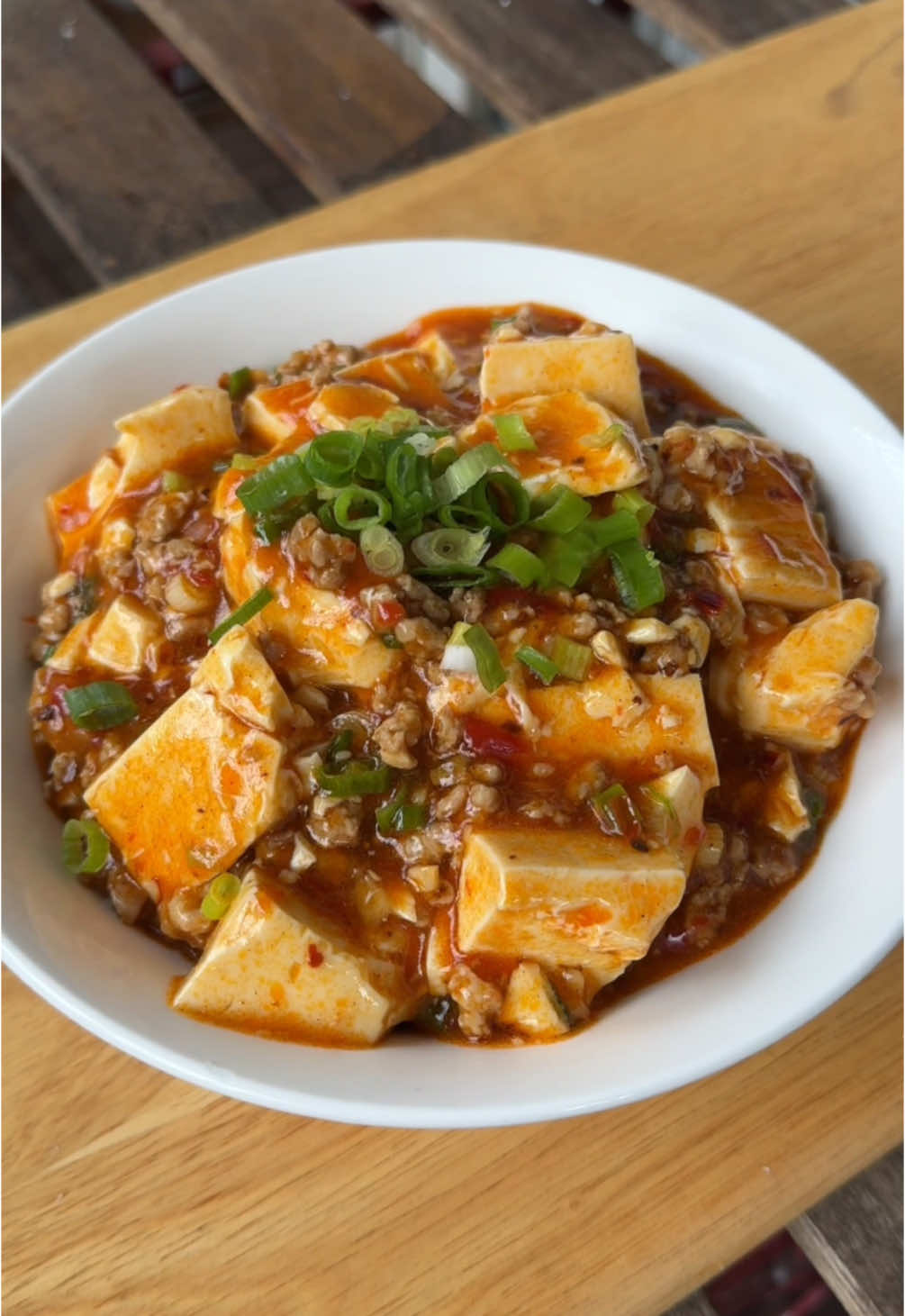 MAPO TOFU 🍚🔥 It’s fiery, mouth tingling, and packed with flavour! - 2 tbsp vegetable oil - 1 tbsp minced garlic - 1 tbsp minced ginger - 200g pork mince - 1 tsp ground Sichuan pepper - 1/2 tsp Chinese five spice (optional) - 2 tbsp spicy bean sauce - 2/3 cup chicken stock - Cornstarch slurry (1/4 cup water and 1 tsp cornstarch) - 600g silken tofu, cut into cubes - 1/4 cup chilli oil (recipe on my feed) - 1/2 tsp sesame oil - 1 tsp caster sugar (or to taste) - 2 spring onions, sliced Heat the vegetable oil in a deep saucepan or wok over medium heat. Add the minced garlic and ginger, stirring for 1 minute until fragrant. Turn up the heat and add the pork mince, breaking it into smaller pieces with a wooden spoon or spatula. Cook until golden brown, about 6–8 minutes. Stir in the ground Sichuan pepper, Chinese five spice, and spicy bean sauce and cook for 1 minute. Pour in the chicken stock and stir for 2–3 minutes. Reduce the heat to medium and add the cornstarch slurry while stirring continuously until the sauce thickens. Gently add the silken tofu and chilli oil, tossing carefully to coat. Let it cook for 5 minutes, then stir in the sesame oil, caster sugar (adjust to taste), and half the sliced spring onions. Serve immediately with steamed rice, garnished with the remaining spring onions. Note: Sichuan pepper and spicy bean sauce (Doubanjang) can be found at most Asian grocers. #MapoTofu #ChineseFood #AsianRecipes #HomeCooking #EasyRecipes #ComfortFood #QuickDinner #Tofu 