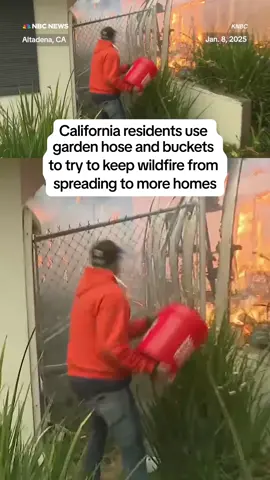 Altadena, #California, residents use a garden hose and buckets of water to try and prevent a #wildfire from spreading to another home.