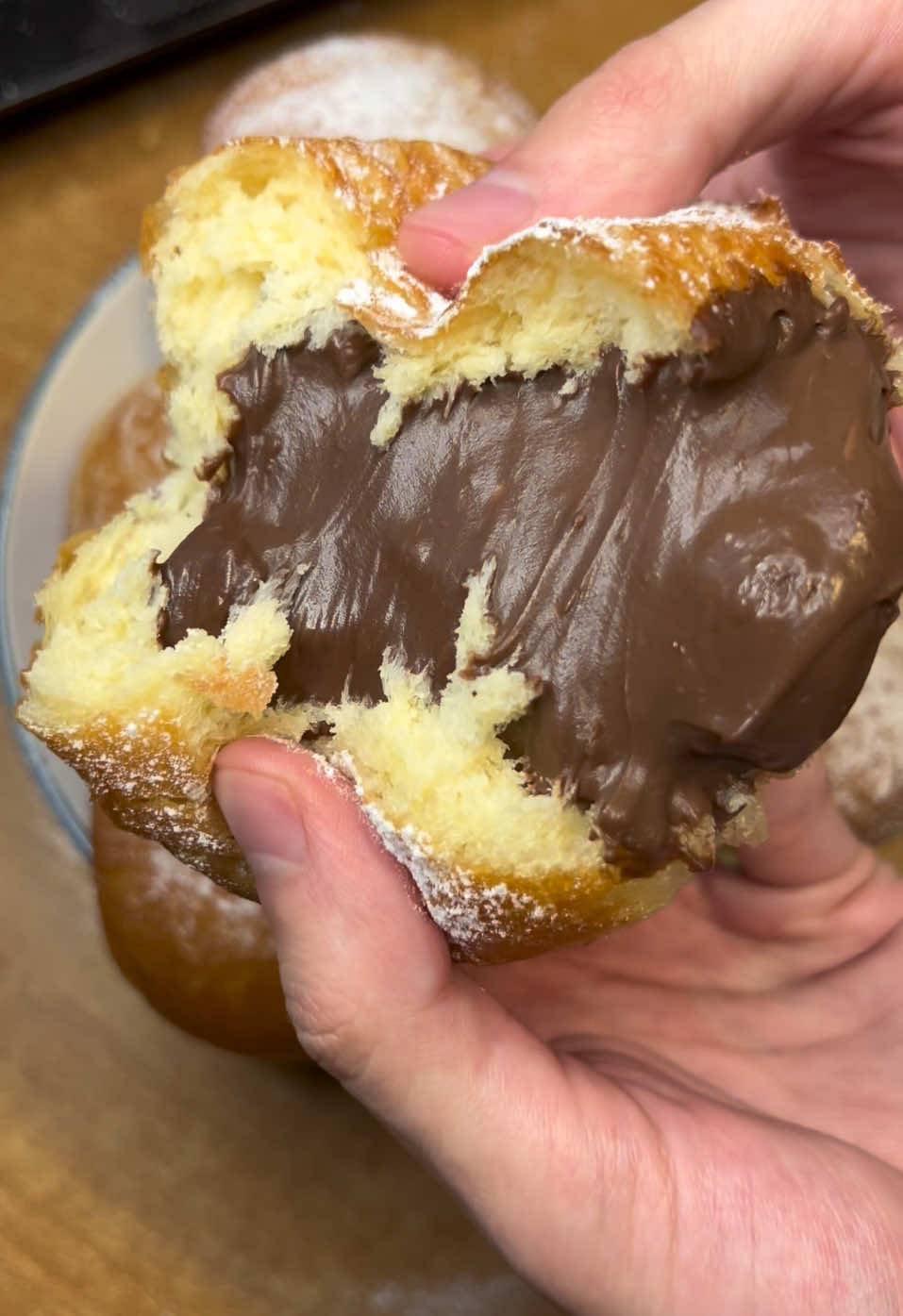 Тгк: lemonello  Те самые пончики из детства 🥹Воздушные, ароматные с шоколадным кремом 😍😍 За рецепт спасибо @Микола Люлько  Ингредиенты:  ▫️Яйца - 2 шт + 2 желтка ▫️Молоко - 250 мл ▫️Мука - 500-550 гр ▫️Сухие дрожжи - 7 гр (или 25 гр свежих) ▫️Сахар - 70 гр ▫️Пьянящая жидкость - 10 гр (1 ст.л) ▫️Соль - 1/2 ч.л ▫️Ваниль - щепотка ▫️Размягченное/растопленное сливочное масло - 100 гр ▫️Сахарная пудра (для обсыпки) В отдельную емкость разбейте яйца и объедините между собой. Молоко смешайте с сухими дрожжами и тщательно перемешайте. Затем добавьте сахар, саль, и ваниль для аромата. Влейте яичную массу, чуток водочки и хорошенько объедините. Если вы полностью уверены в эффективности дрожжей значит опару можно не делать, а сразу смешать все ингредиенты. Просейте муку в два-три приема и хорошо перемешайте. Добавьте размягченное или растопленное сливочное масло в два приема и замешайте тесто. С начало может показаться что тесто получилось через чур плотное, но когда добавите масло то увидите что все идет как надо. Оно получится мягким и не будет липнуть к рукам. Хотя все же количество муки я бы немного уменьшил. Накрываем тесто пакетом, сверху еще сухим полотенцем и отправляем в теплое место на часик. За это время оно должно увеличится вдвое, а пока приготовим шоколадный заварной крем.  Ингредиенты: шоколадный крем ▫️Молоко - 800 мл ▫️Яйца - 2 шт ▫️Сахар - 180 гр ▫️Ваниль - щепотка ▫️Какао - 26 гр ▫️Кукурузный крахмал/мука - 80 гр ▫️Шоколад (темный/молочный) - 100 гр ▫️Размягченное сливочное масло - 100 гр В сотейнике смешиваем яйца, сахар и ваниль. Следом закиньте какао и кукурузный крахмал, его можно заменить на муку. Объедините до однородности и влейте теплое молоко. Поставьте на плиту и на среднем огне непрерывно помешивая уварите крем до загустения. Затем снимите с огня, дайте немного остыть и закиньте темный шоколад. Хорошо перемешайте и добавьте размягченное сливочное масло. Еще раз тщательно перемешайте, накройте пленкой в контакт и отправьте остывать.  Когда тесто уже подошло  отделяем небольшую часть и скатываем в шарик, и делаем так с остальной частью. Выкладываем готовые шарики, накрываем полотенцем, и оставляем в теплом месте что бы они увеличились в объеме. В это время разогреваем растительное масло до температуры 175-180 градусов. Аккуратно закидываем сформованные шарики и жарим по 1-2 минуты с каждой стороны. Тут важно не отвлекаться и время от времени проверять готовность, и переворачивать только тогда, когда половина достаточно зарумянилась.  Достаем пончики, сливаем лишний жир, и выкладываем на тарелку застеленую салфетками.  Готовые остывшие пончики я выкладываю в форму и с помощью деревянной шпажки проделываю дырочки. Затем начиняю готовым шоколадным кремом с помощью кондитерского мешка. Вторую половину решил начинить малиновым джемом. Остается посыпать сахарной пудрой для красивого вида и можно звать родных. По этому рецепту пончики получились именно такими, какими я их представлял. Воздушными, ароматными, с большим количеством начинки. Рецепту ставлю заслуженные миллион баллов. #пончики #выпечка #рецепт 