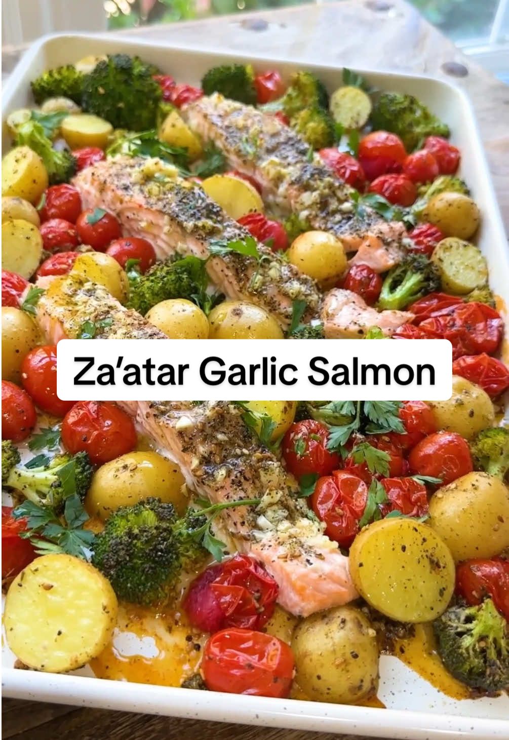 Za’atar Garlic Salmon Recipe - This salmon recipe is the next recipe in my 30-Day Mediterranean Diet Meal Plan!  Salmon and vegetables are seasoned with garlic, za’atar and coriander, tossed on a sheetpan and baked until the salmon is tender and flaky (Bake at 400 defrees F for 15-16 minutes.) You eat this sheet pan salmon on it’s own or serve it with a Mediterranean salad.  Ingredients:  12 baby potatoes 2 cups grape tomatoes 6 oz broccoli florets 5-6 garlic cloves, minced Extra Virgin Olive Oil Salt and pepper 2 tsp Za'atar spice 1 tsp coriander, divided 1 lb salmon fillet, no skin 1 lemon If there is one seasoning blend I absolutely cannot live without, it's za'atar! This aromatic Middle Eastern blend of herbs, sesame seeds, and sumac will transform your cooking! #salmonrecipe #zaatarsalmon #zaatar #salmon #sheetpansalmon #easysalmonrecipe #mediterraneansalmon #mediterraneandiet #mediterraneanfood #mediterraneandietrecipes #mediterraneandietmealplan #mealplan #mealplanideas #HealthyMealPlan #mediterraneandietmealplan #garlicsalmon #zaatarrecipes #zaatarrecipe 