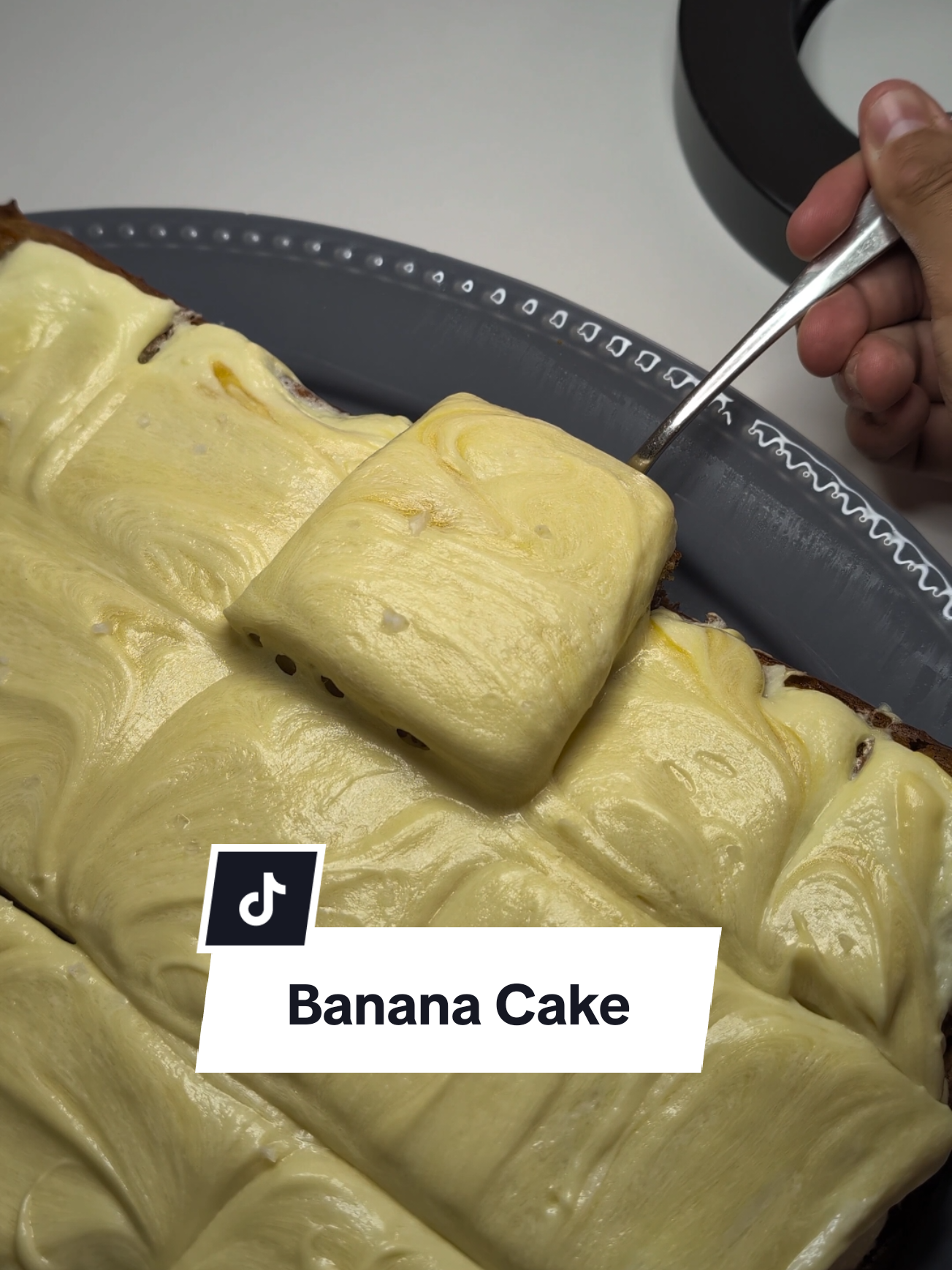 Zaddy's Banana Cake 😋 Ingredients: Cake Mix: - 1/2 cup salted butter  - 3/4 cup brown sugar  - 1/2 granulated sugar  - 2 eggs - 1 cup Greek yogurt  - 3 bananas mashed  - 1 tsp vanilla extract  - 2 cups all-purpose flour  - 1 tsp baking soda  - 1/2 tsp salt - 1/2 tsp cinnamon  Cream Cheese Frosting: - 1 block cream cheese, room temp - 1 tsp vanilla extract  - 2 cups icing sugar  - caramel sauce (store bought)  - flaky sea salt  Instructions: 1) Preheat Oven to 175'C and prepare 8x8 baking tray and line with baking paper 2) brown your butter. place butter in saucepan and heat on medium until butter starts to brown, stirring continuously. take off stove to let cool down 3) In a bowl add butter with sugars, whisk and then add eggs,yogurt,banana,vanilla and whisk well until combined  4) add in your dry mix which is a whisked bowl of flour,baking soda,salt and cinnamon. whisk until just combined  5) place cake mix in tray, smooth out and put in oven for 40 minutes until golden brown  6) while cake is cooling out of oven, make frosting with the cream cheese, sugar, vanilla. layer that over the cake  7) add your caramel sauce over frosting and swirl around to combine  8) top with Flaky Sea salt 9) Enjoy! #recipes #cakes #baking #treats #homecooking #bananas #creamcheese #banana #dessert #fyp 