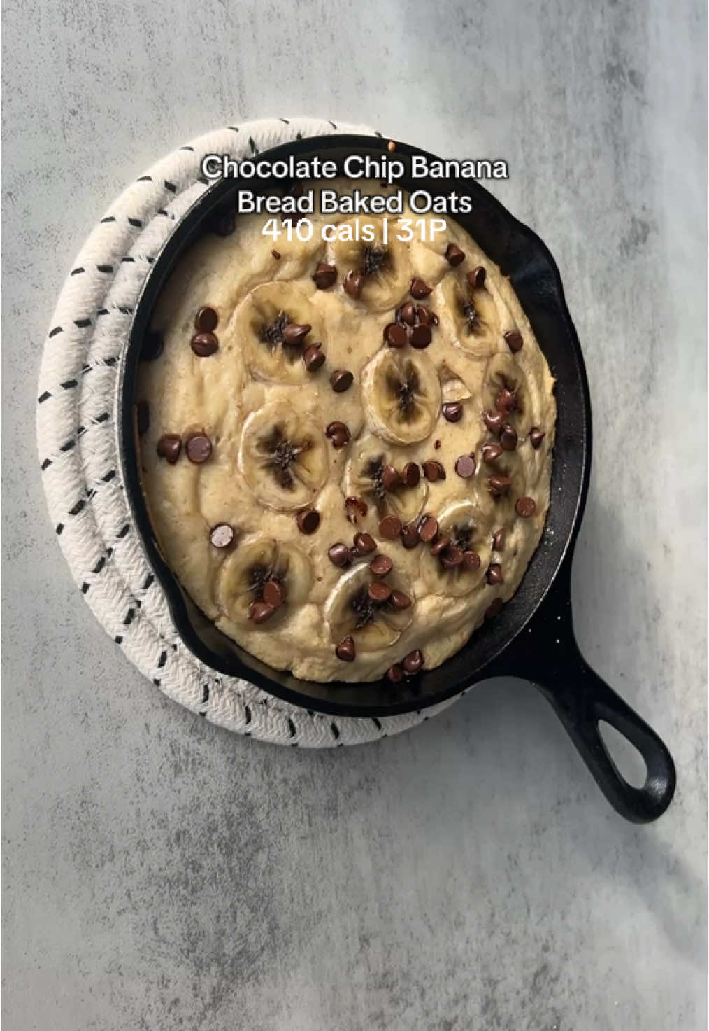 Replying to @dessyg Chocolate chip banana bread baked oats 🍫🍌 Nutrition: 410 cals, 31P, 55.5C, 8.5F Ingredients: -45g oat flour -25g @pescience vanilla protein powder (discount code FIT15) -5g @lakanto brown Monkfruit sweetener -2g baking powder -50g nonfat Greek yogurt -100ml unsweetened almond milk -70g sliced banana -12g mini chocolate chips Directions: -Preheat the oven to 400F -Mix all the ingredients (except the last two) together in a bowl -Mix in half the banana slices and chocolate chips -Spray a mini 6 inch cast iron skillet with cookie spray, then top with rest of the sliced banana and chocolate chips -Bake for about 18 mins, or until fork comes out clean (I would check around the 13-14 min mark) then enjoy 🤤 #bakedoats #pescience #highprotein #lowcalorie