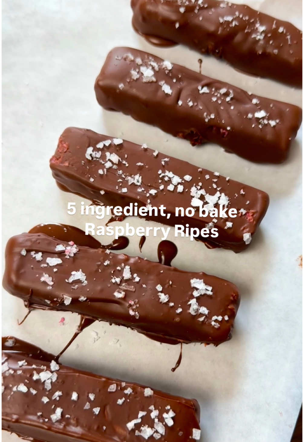 5 ingredient no bake raspberry ripes  Make with caution because these are addicting affff  Ingredients:  200g frozen raspberries  140g desiccated coconut  1/4 cup maple syrup  300g choc of choice  Flaky sea salt  #5ingredients #healthysnacks #healthydessert #lunchboxsnacks 