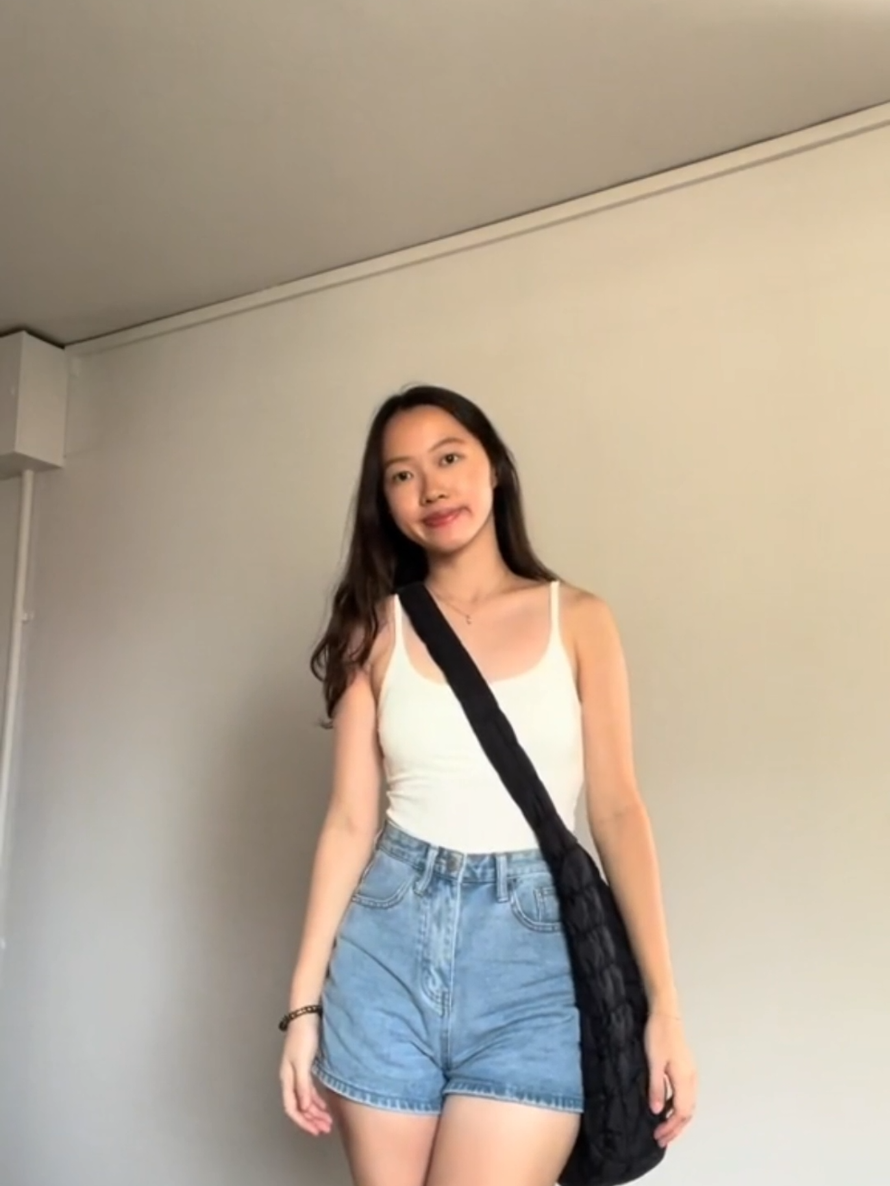 A simple but nice padded cropped women singlet from einashop styled with natalie denim shorts and Valence puffer cloud bag. Your perfect style for school.  #einashop #ootdfashion #paddedtop #denimshorts #pufferbag #cloudbag #styletips 