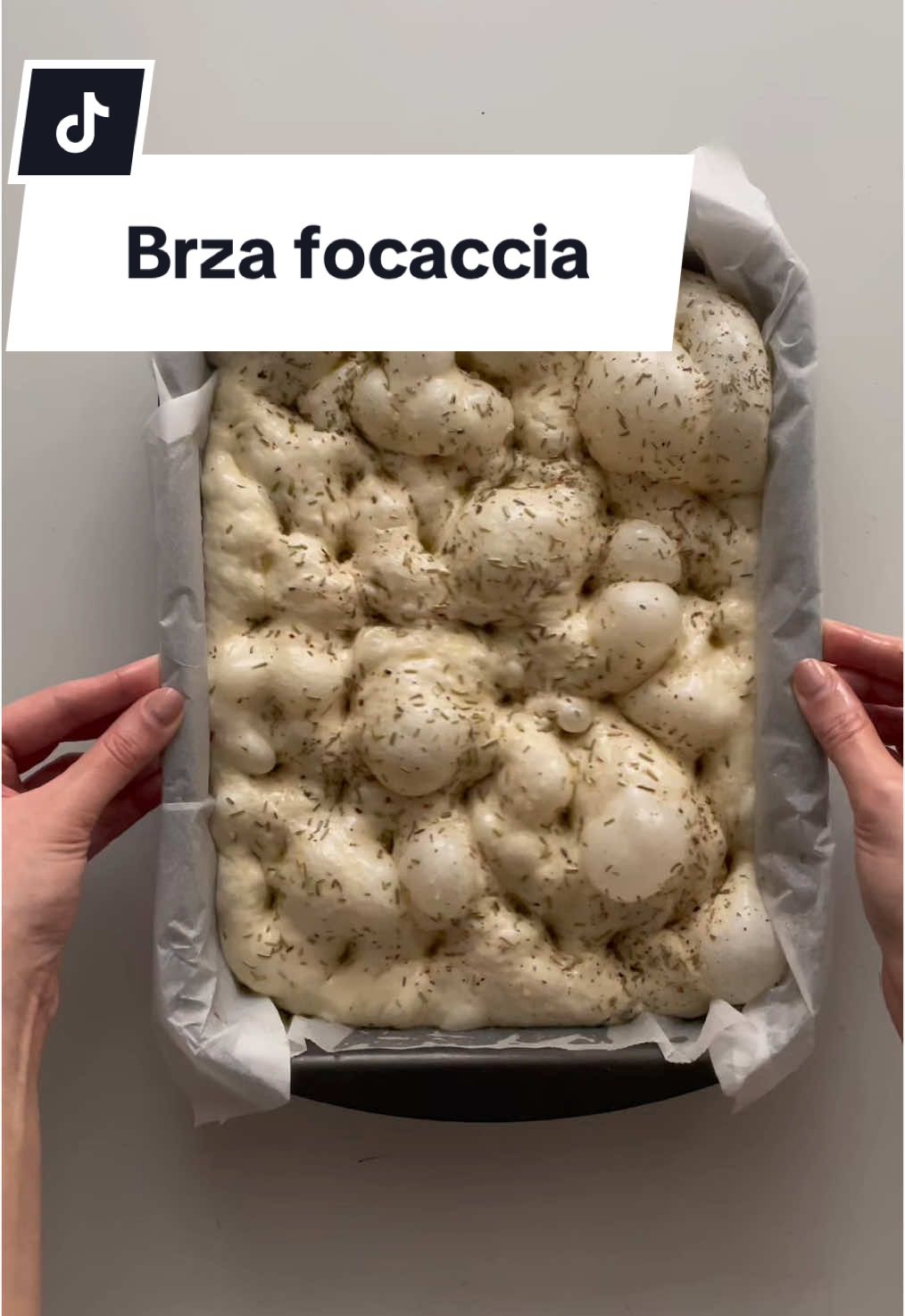 Brza focaccia u 2 i pol sata 😍 SASTOJCI  ⁃ 400g mlaka voda  ⁃ 21g svježi kvasac  ⁃ 1 žličica šećer ili med ⁃ 500g brašno tip 00 (zamjena - glatko) ⁃ 15g sol  ⁃ maslinovo ulje (samo maslinovo koristimo!) ⁃ Kotányi ružmarin  ⁃ Kotányi začinsko bilje na talijanski  RECEPT  1. Izmiješajte mlaku (prema toploj) vodu, izmrvljeni kvasac i šećer/med pa pokrijte krpom na 5min  2. Dodajte brašno i sol te miješajte kuhačom 3-5min  3. Nauljite zdjelu i tijesto odozgo pa dižite pokriveno krpom 20min (svo dizanje treba biti u najtoplijoj prostoriji) 4. Napravite prvu rundu od po 4 preklapanja (tijesto izvucite od dna i preklopite) pa tijesto dižite 20min pokriveno krpom  5. Napravite drugu rundu od po 4 preklapanja pa tijesto dižite još 20min pokriveno  6. Nauljite dno i strane tepsije, obložite ju papirom za pečenje pa i njega nauljite po dnu i stranama, a pećnicu stavite grijati na 240C  7. Napravite treću rundu od po 4 preklapanja pa tijesto odmah stavite u tepsiju  8. Preklopite ga od gore na sredinu i od dolje na sredinu, pa preokrenite da je glatkom stranom prema gore  9. Prekrijte prozirnom folijom tako da ona ne dira tijesto pa ga dižite 20min  10. Maknite foliju pa tijesto nauljite i pospite Kotányi ružmarinom i Kotányi začinskim biljem na talijanski 11. Napravite udubljenja (utisnite prstima i malo umasirajte) u podjednakim razmacima  12. Pecite 10min na 240C pa 15min na 220C (ukoliko želite hrskavije dno, zadnjih 5min maknite papir za pečenje iz tepsije i pecite bez njega) #focaccia #recept #Recipe #foccacia #brzafoccacia #brzafoccacia #quickfocaccia #jednostavnirecepti #nokneadfocaccia #brzirecepti #kotanyi #kotanyihrvatska 