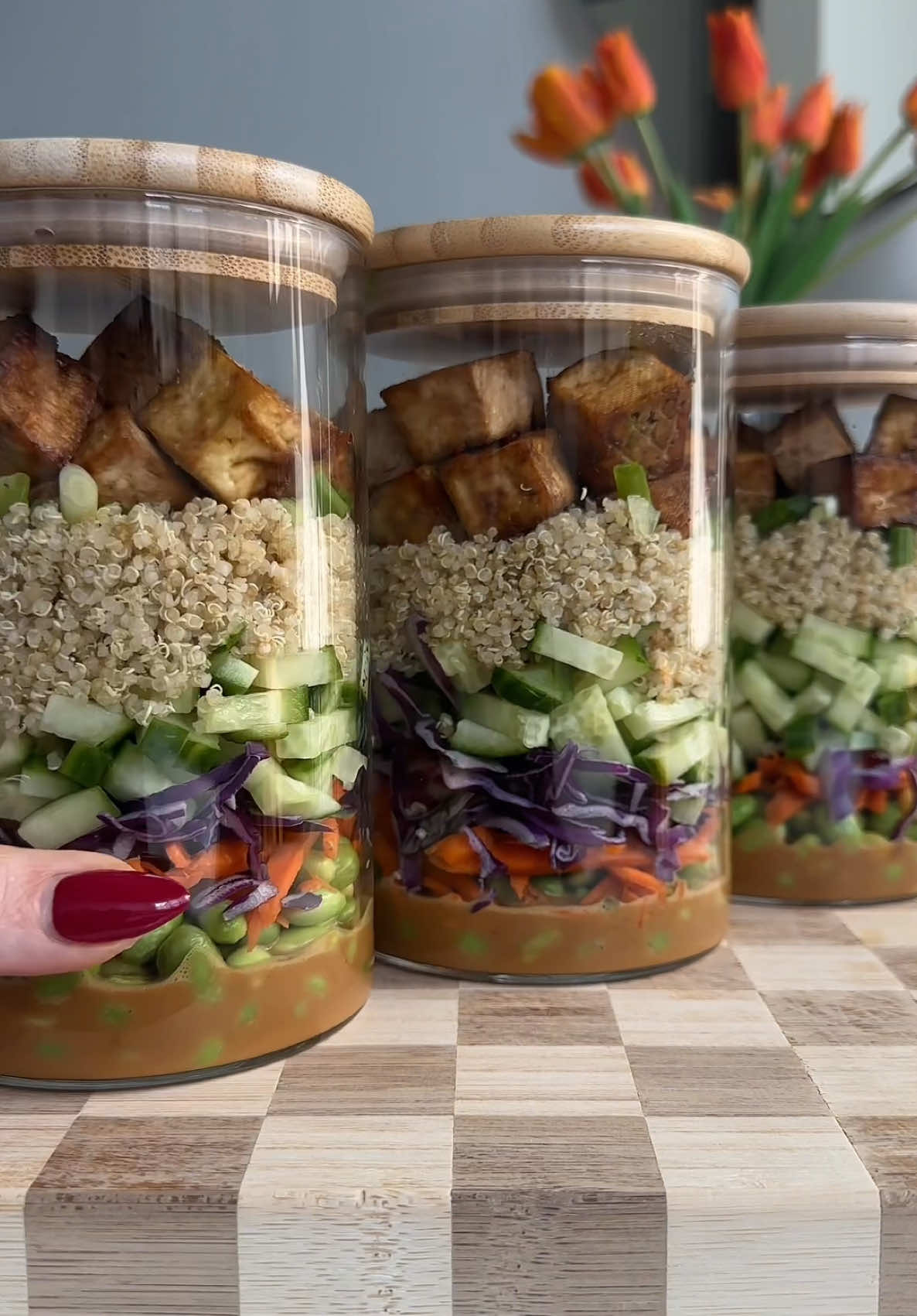 Peanut tofu salad jars!!!  Makes 3-4 jars  Ingredients 1 16 oz block extra firm tofu 2 tbsp coconut aminos 1 tbsp soy sauce 1 tsp garlic powder 1 tsp onion powder Cooked quinoa (I just buy frozen because it’s easy to make in the microwave) 1 cucumber Shredded carrots Shredded purple cabbage 3 green onions  1 1/4 cups edamame (also buy frozen)  Peanut dressing 1/3 cup powdered peanut butter 3 tbsp coconut aminos 2 tsp lime juice  1 tbsp maple syrup 2 tsp sriracha  1 tsp garlic powder 1/2 tsp onion powder 3 tbsp Warm water (add more 1 tbsp at a time if too thick) 1. Press tofu: drain of excess water then wrap in towel and place on flat surface, put something heavy on top like a cookbook or cutting board to press out excess water, let sit for an hour.  2. Dice tofu into cubes then add to a large bowl and cost with coconut aminos, soy sauce, garlic and onion powder. Transfer for air fryer and spray tofu with olive oil cooking spray. Air fry at 425F for 15 minutes or until crispy. 3. While tofu cooks, cook quinoa according to package instructions and let cool. Then prep all your veggies 4. Whisk together dressing ingredients adding more water 1 tbsp at a time if too thick. Whisk together until smooth. 5. Assemble jars. To the bottom add dressing then layer with edamame, carrots, cabbage, cucumber, quinoa, green onion, and tofu. Store in the fridge for up to 4 days! #tofurecipe #healthyrecipe #mealprep #saladrecipe 