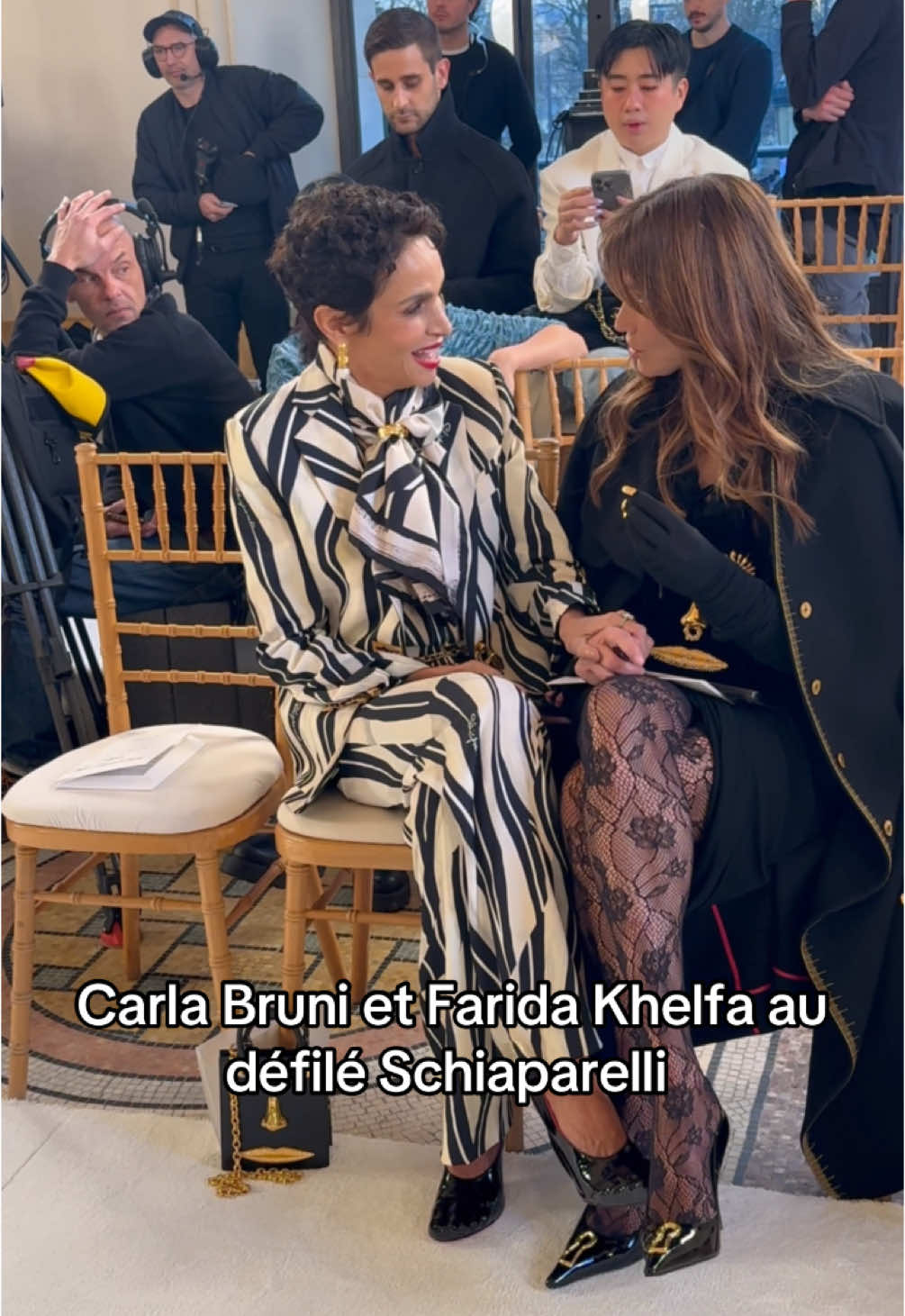 👑Carla Bruni dans une robe drapée noire Schiaparelli, des collants en dentelle noire, des talons noirs, et Farida Khelfa porte un blazer imprimé noir et blanc, un chemisier et un pantalon assortis, des talons noirs, lors du défilé Haute Couture Printemps-Été 2025 dans le cadre de la Fashion Week de Paris le 27 janvier 2025 à Paris. #Schiaparelli #hautecouture #faridakhelfa #carlabruni #fashionweek #pfw #parisfashionweek #fashionweek2025 