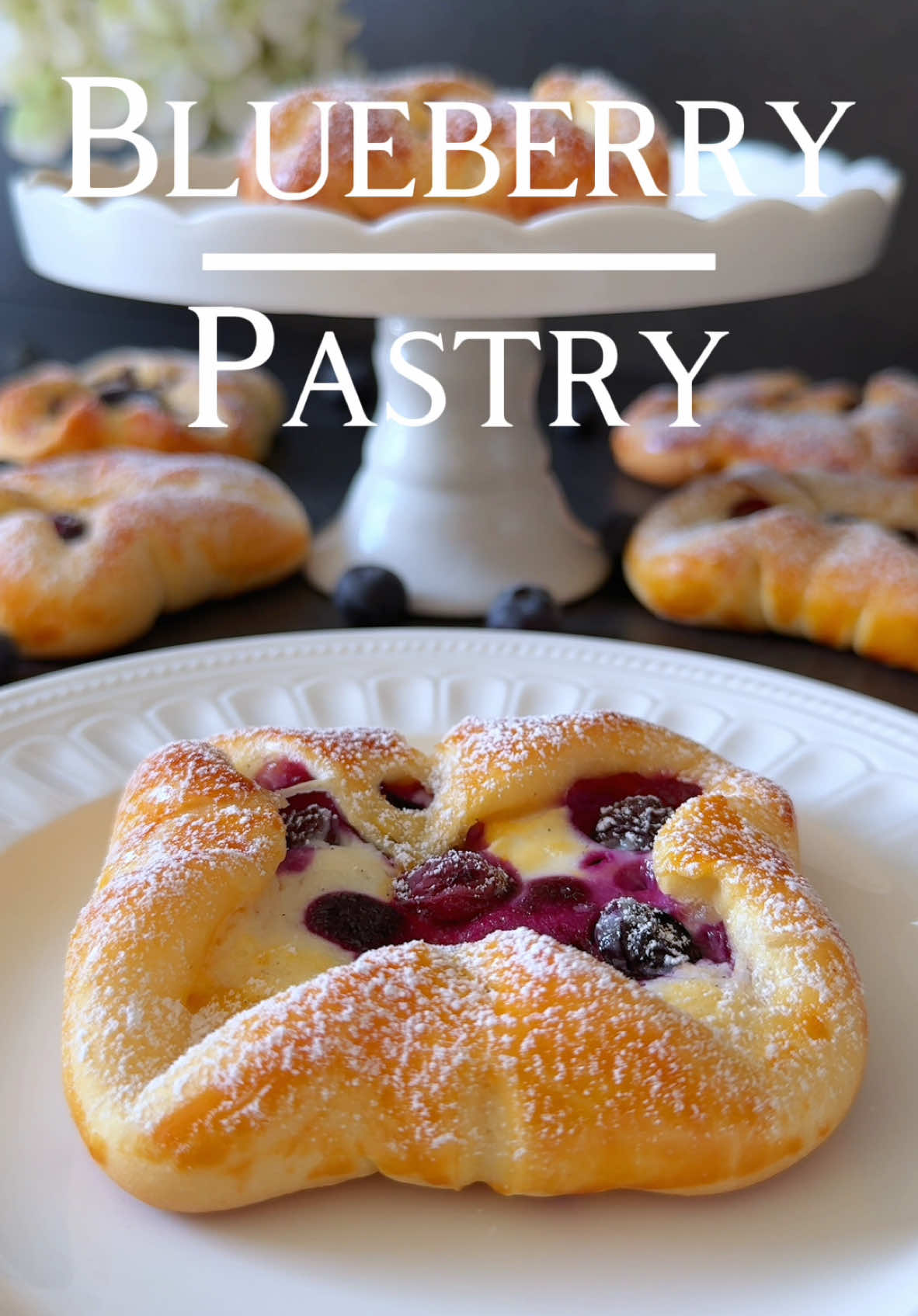 Ad | Blueberry Pockets Recipe 🫐🤍 Soft and fluffy pockets filled with a creamy cheese and blueberry mixture – perfect for a sweet treat! 🥰 📝Ingredients: (Makes 8–10 pockets) For the dough: • 250 g all-purpose flour, sifted (about 2 cups) • 30 g sugar (about 2 ½ tbsp) • 1 pinch of salt • 1 tsp instant yeast • 110 ml lukewarm milk (about ½ cup) • 40 g soft butter (about 2 tbsp) • 1 egg (size M) For the filling: • 150 g quark or unsalted cream cheese (about 2/3 cup) • 30 g sugar (about 2 ½ tbsp) • 1 tsp vanilla extract • 100 g fresh blueberries (about 2/3 cup) For brushing: • 1 egg yolk For decorating: • Powdered sugar 🤍Preparation: 1.	Mix flour, yeast, 1 tsp sugar, and 2–3 tbsp milk in a well. Let it sit for 10–15 minutes until frothy. 2.	Add the remaining milk, sugar, salt, butter, and egg. Knead until smooth. Let it rise for 1 hour. 3.	Divide dough into 10 portions (about 50 g each), roll into squares. 4.	Fill each square with 1 tbsp quark mixture and blueberries. Fold corners to seal and add a blueberry in the center. 5.	Place on a parchment-lined baking sheet, rest 20 minutes. 6.	Brush with egg yolk, bake at 180 °C (350 °F) for 15–20 minutes. 7.	Cool slightly, cover to keep soft, then dust with powdered sugar. Enjoy! 🤍