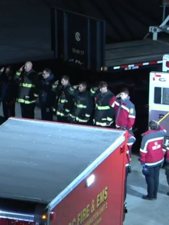 First responders stand in solemn honor as they carry the flag-draped remains of an unidentified victim recovered after a midair collision between an American Airlines flight and a Black Hawk helicopter.