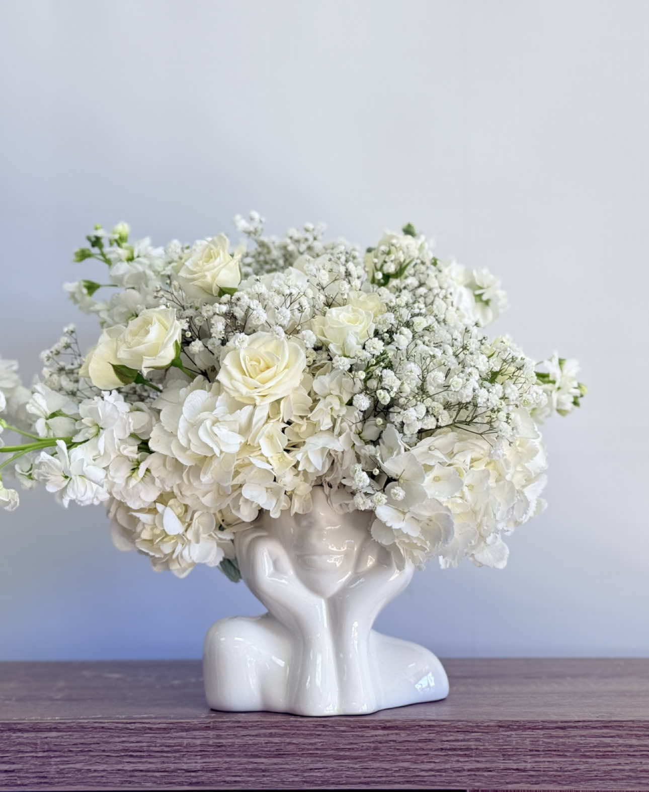✨ Introducing our Head In The Clouds arrangement! ☁️🤍🌸 This dreamy design features a white ceramic head vase filled with the softest white roses, hydrangeas, stock, and delicate baby’s breath, creating the perfect touch of elegance and serenity. 🌿 🌟 Need the perfect gift or home decor that radiates freshness and love? Here are some tips to keep your flowers looking their best: 1️⃣ Trim the stems at a 45-degree angle before placing them in water. 2️⃣ Refresh the water every day to keep them hydrated. 3️⃣ Keep your flowers out of direct sunlight to preserve their beauty for longer! 🌞 4️⃣ Hydrangeas can drink from their head! Mist the top with a bottle of water to extend the life of your arrangement.  Family-owned and locally loved, we’re proud to serve the Glendale, Arizona community with the finest, hand-selected blooms. 🌹 Whether you’re celebrating a special occasion or just because, Head In The Clouds is here to brighten your day. 💐 Shop local, support small businesses, and bring some joy into your home today. 🏡💖 #HeadInTheClouds #FlowerArrangement #FloralDesign #LocalFlowerShop #SupportSmallBusiness #FamilyOwned #GlendaleAZ #FlowerPower #FreshFlowers #HomeDecor #LuxuryFlowers #FlowersOfTheDay #ArizonaFlowers #FlowerLovers #BringingBeautyHome #FloralArt #RoseLovers #HydrangeaLove #StockFlowers #BabyBreathMagic #FlowerShopGoals #GiftIdeas Let us know your favorite flower! 💬