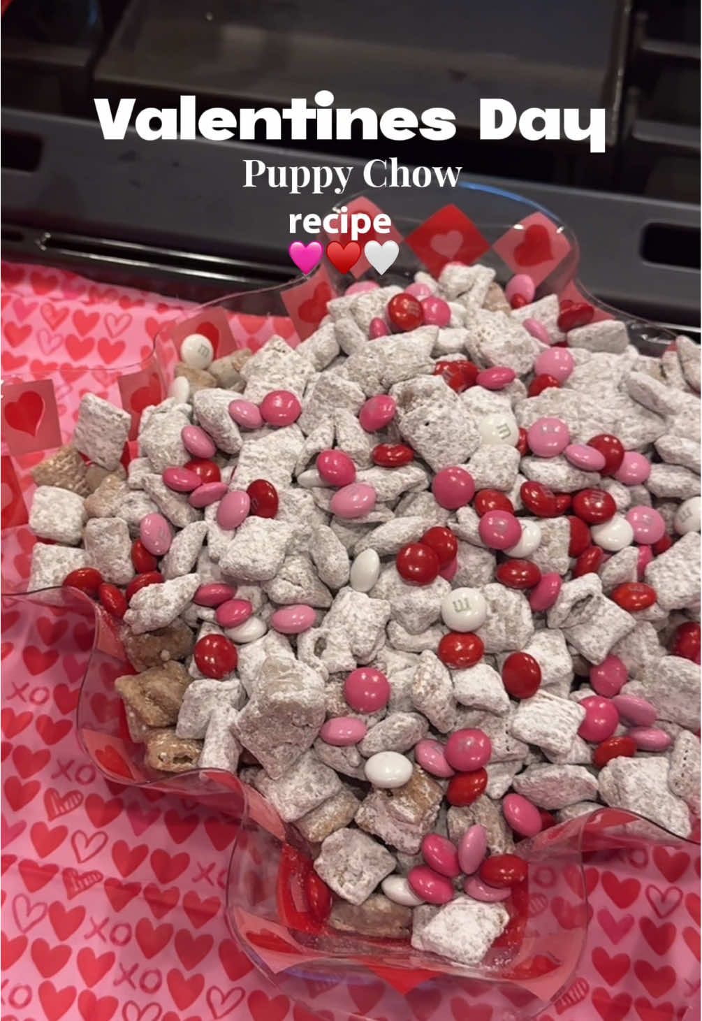 Valentines puppy chow “muddy buddy’s” are the best. ♥️🩷🤍Recipe below: ✨1 box chex mix  ✨1/4 cup butter ✨1 jar smooth peanut butter  ✨1 jar milk chocolate chips  ✨1/2 bag of powdered sugar  ✨ seasonal m&ms  1. Into large bowl, pour cereal; set aside. 2. In microwavable bowl, microwave chocolate chips, peanut butter and butter uncovered on High 1 minute; stir. Microwave about 30 seconds longer or until mixture can be stirred smooth. Pour mixture over cereal, stirring until evenly coated. Pour into 2-gallon resealable food-storage plastic bag. 3. Add powdered sugar. Seal bag; shake until well coated.  #galentinesday #galentinesparty #muddybuddies #puppychow #ValentinesDay #valentinedessert #glutenfreedessert #recipes  @Chex Mix @M&M'S US 