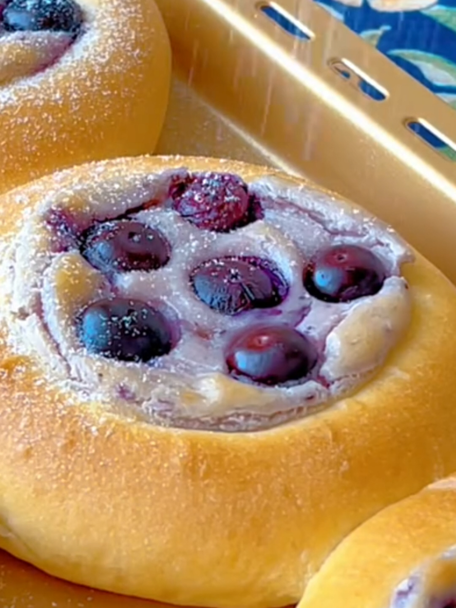 Blueberry Basque Bread Recipe 👇 👉 Ingredients For the Dough: 2 ½ cups all-purpose flour 2 tablespoons sugar ½ teaspoon salt 1 teaspoon instant yeast ¾ cup warm milk 2 tablespoons unsalted butter, softened For the Cream Cheese Filling: 4 oz (½ cup) cream cheese, softened 2 tablespoons blueberry jam (or any fruit jam) 1 teaspoon powdered sugar (optional, if using unsweetened jam) For Assembly: 1 egg yolk (for egg wash) ½ cup fresh blueberries Powdered sugar, for dusting Directions: Make the Dough: In a large bowl, mix the flour, sugar, salt, and yeast. Gradually add warm milk while stirring. Knead until a rough dough forms, then add the softened butter and knead until smooth. If using a stand mixer, knead on medium speed until the dough reaches 80-90% elasticity (it should stretch without tearing easily). First Rest: Shape the dough into a ball, cover with a towel, and let it rest for 20 minutes. Divide and Shape: Divide the dough into 6 equal portions (about 2.25 oz or 64g each). Flatten each piece to release air, then shape into smooth balls. Cover and let them rest for another 20 minutes. Roll and Proof: Roll each dough ball into a 4-inch (10 cm) circle and place on a lined baking sheet. Place a small cup of warm water in the oven (turned off) and let the dough proof until slightly puffy, about 30 minutes. Make the Filling: In a small bowl, mix cream cheese and blueberry jam until smooth. If you prefer it sweeter, add powdered sugar. Transfer to a piping bag for easy filling. Assemble: Once proofed, press a deep indentation in the center of each dough round using your fingers. Brush the edges with egg wash. Pipe a generous amount of cream cheese filling into the center and top with fresh blueberries. Bake: Preheat the oven to 350°F (180°C). Bake for 16 minutes, or until golden brown. Finish: Let the bread cool slightly, then dust with powdered sugar before serving. Prep Time: 40 mins | Cook Time: 16 mins | Total Time: 56 mins | Servings: 6 | Calories: ~220 Kcal per bread ✅ Enjoy warm or at room temperature! These are soft, slightly chewy, and perfectly creamy inside. #creatorsearchinsights #Recipe #EasyRecipes #yummy #yum #cookingathometiktoktv #foryoupage 