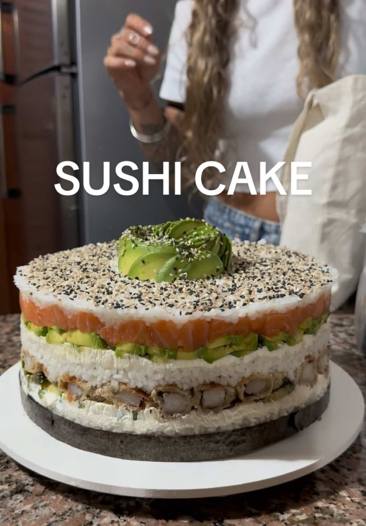 SUSHI CAKE 🍣🎂🥢 para todos los amantes del sushi como mi mari2 😘  Vas a necesitar 🍚 Para el arroz: -600g arroz para sushi  -85ml vinagre de arroz (en caso de no tener, se puede hacer con vinagre de alcohol pero queda mucho mejor con el de arroz) -50g azúcar -35g sal (mejor si fuera ajinomoto pero yo no tenía) 🍣Para el armado: -600g queso untable tipo phila -4/5 paltas  -25 langostinos rebozados -300g salmón fresco 🎂Para decorar: -2cdas semillas de sésamo -2 paltas (para hacer la florcita) -1/2 lamina de alga nori 🥢 Para servir: - Salsa de soja - Salsa Buenos Aires  ⚠️TIPS IMPORTANTES - Es CLAVE lavar el arroz antes de cocinarlo! Mínimo hay que enjuagarlo 11 veces, o hasta que el agua salga transparente.  - Respetar los tiempos de cocción del arroz: primero 2 min a fuego medio/alto, luego 13 min a fuego mínimo y por último 10 min más fuera del fuego con la tapa puesta! - Agregar el vinagre cuando el arroz esté todavía caliente. - Dejar enfriar el arroz a temperatura ambiente y tapado con papel film para que los granos de arriba no se resequen. - Para el armado tener en cuenta que lo que quede contra la pared del molde es lo que luego va a quedar a la vista: colocar el lado más verde de la palta hacia la pared, la parte interna de los langostinos hacia afuera, acomodar los pedacitos de salmón prolijamente en los bordes, etc. Diga torta rindió para que picoteemos 25 personas, y también hice una salsita Bs As que si quieren que se las enseñe me lo dejan en comentarios 🫶🏼 igual que la florcita de palta!!  Si les queda alguna duda me la dejan acá abajo🩷 espero que la intentennnnn y me etiqueten si lo hacen 😍 Gracias por ver 🥢💘✨