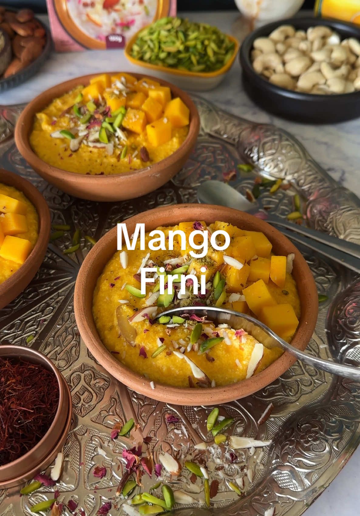 Mango Firni !  @Heerafood  AD! Sweeten your day with this vibrant mango firni! The combo of saffron, almond, and mango is simply divine. Topped with fresh fruits and nuts, it’s not just a dessert; it’s an experience!  Ingredients: - Milk: 1 liter (full-fat for creamier texture) - Heera Saffron and Almond Firni Mix: As per package instructions (typically around 150g ) - Heera Mango Pulp: 100g - Fresh Mango Cubes: For garnish (1 small-sized mango should suffice) - Almonds: Sliced or chopped, for garnish (about 1 tablespoons) - Pistachios: Chopped, for garnish (about 1 tablespoons) - Edible Dried Rose Petals: For garnish (a handful, optional) Instructions: - Begin by soaking the clay bowls in water for about 15-20 minutes. This helps to keep them from cracking when hot firni is poured in. After soaking, remove them from the water and let them dry completely. - In a large pot, pour in the 1 liter of whole milk. Place the pot on medium heat and allow the milk to warm up slowly. Stir occasionally to prevent it from sticking to the bottom. - Once the milk is just about to boil (you'll see small bubbles forming), lower the heat slightly. Gradually add the Heera saffron and almond firni mix to the milk while stirring continuously. This prevents lumps from forming. - Continue to cook the mixture on low to medium heat, stirring frequently, until it thickens. This process may take around 15-20 minutes. Keep an eye on the consistency; you want it to be thick enough to coat the back of a spoon. - At this point, add a few strands of saffron to the mixture for extra flavor and a beautiful golden color. Stir well to ensure the saffron is evenly distributed. - Once the firni has reached your desired thickness, add the Heera mango puree to the pot. Stir well to combine all the ingredients, and let it cook for another 8-10 minutes on low heat. This allows the flavors to meld together. - Once cooked, remove the pot from the heat and allow the firni to cool down slightly. Pour the firni into the prepared clay bowls, filling them generously. - Cover the bowls with plastic wrap or lids and refrigerate them for at least 2-3 hours, or until completely chilled. This will enhance the flavors and the firni will set perfectly. - Before serving, remove the firni from the refrigerator. Top each bowl with fresh mango cubes, a sprinkle of sliced almonds and chopped pistachios, and a few edible dried rose petals for a beautiful presentation. - Serve the firni directly in the clay bowls for an authentic touch. Enjoy!   #firni #kheer