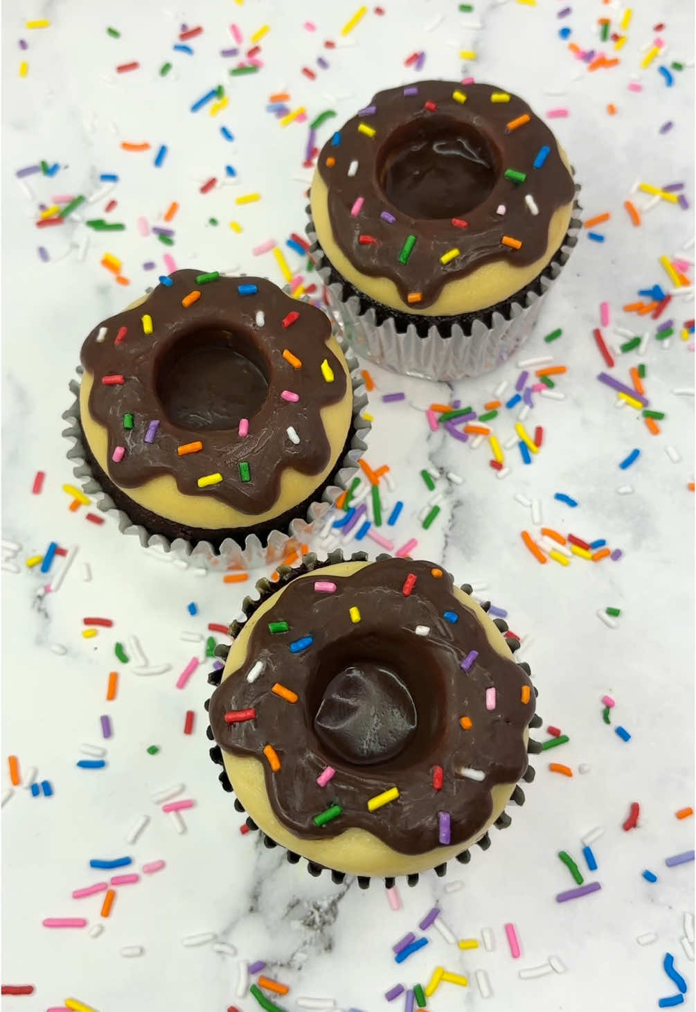 Donut cupcakes 🍩🧁  For those days when you can’t decide which one 🍩🧁🥳 🍩 Add buttercream to your cupcake and push a large piping tip into the middle. 🧁 Chill slightly, just enough to firm up your buttercream and still be able to lift off the piping tip.  🍩 Twist the piping tip and lift it out. 🧁 Decorate with chocolate ganache and sprinkles. #cupcake #cupcakedesign #foodart #cakedbyrach #donuts #minifood #easyideas #pipingskills #cupcakesoftheday #cupcakesforanyoccasion   