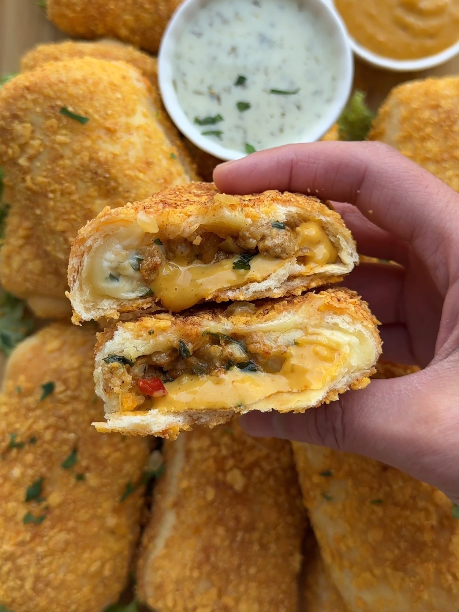 CRUNCHY NACHOS BREAD WITH BEEF #food #Recipe #bread #nachos #chips #beef #cheesy #tasty #Ramadan #ramadan2025 #iftar #fy #fyp #foryoupage #foryou DOUGH 185 ml lukewarm milk 7 g instant yeast (1 tablespoon or 1 packet) 15 g honey 1 egg (medium) 30 g unsalted butter 400 g flour (all-purpose flour) 8 g salt (1⅓ teaspoon) COATING 100 g nachos (cheese flavor) 1 egg (medium) or milk BEEF MIXTURE 25 ml olive oil 150 g yellow onion (1 yellow onion) 50 g red bell pepper (half a red bell pepper) 3.5 g salt (½ teaspoon) 350 g ground beef 2 g cumin powder (⅔ teaspoon) 3 g paprika powder (1 teaspoon) 2 g garlic powder (⅔ teaspoon) 3 g cayenne powder (1 teaspoon) 1.5 g black pepper (½ teaspoon) 10 g fresh parsley 10 g jalapeños 25 g chili sauce 50 g grated cheese EXTRA cheese (to taste) Instructions: Place the lukewarm milk, yeast, and honey in a deep bowl. Mix well and let it rest for 5 minutes. Add the beaten egg, butter, flour, and salt. Knead for 10-12 minutes until smooth. Cover and let the dough rise in a warm spot for 1 hour or until doubled in size. Heat the olive oil in a pan. Add the onion, red bell pepper, and salt. Cook until softened. Add the ground meat, cumin powder, red bell pepper powder, garlic powder, cayenne powder, black pepper, and salt. Cook for about 7 minutes, breaking up the meat as it browns. Stir in the parsley, jalapeños, and chili sauce. Mix well. Sprinkle the grated cheese on top and let it melt. Remove from heat and let the mixture cool. Grind the nacho chips into coarse crumbs using a food processor. Deflate the dough and divide it into 11 equal pieces of about 60 g each. Shape each piece into a ball. Roll out a dough ball into a circle of about 13 cm. Place a slice of cheese on the dough and optionally add sauce to taste. Spoon a portion of the meat mixture on top. Fold the top and bottom of the dough inward. Then fold the left side inward and roll the dough over the filling. Pinch the edges tightly to prevent the filling from leaking during frying. Turn the rolls over and brush them with the beaten egg. Then coat them in the ground nacho chips and place them on a baking sheet lined with parchment paper. Let them rise in a warm place for 30 minutes. Heat a layer of sunflower oil to 175°C (350°F). Fry the nacho bread in batches until golden brown and crispy. Drain on paper towels.