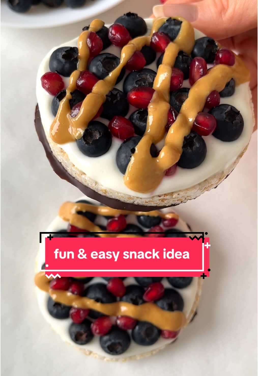 A fun & easy snack idea!🤩  • Ingredients: 2 rice cakes 2 pieces 80 % dark chocolate, melted Greek yogurt Blueberries Pomegranate seeds Peanut butter • 1. Spoon two dollops of melted dark chocolate onto a plate lined with parchment paper. Place the rice cakes on top and press them down to spread the chocolate. Let set in the fridge for 10 minutes 2. Top with greek yogurt, blueberries, pomegranate seeds and peanut butter and enjoy! • For more recipes check out my recipe Ebooks which have 180 healthy & easy recipes, link is in my profile🥰 • • • #snackidea #snackideas #healthysnack #healthysnacks #healthysnackideas #healthysnackrecipes 