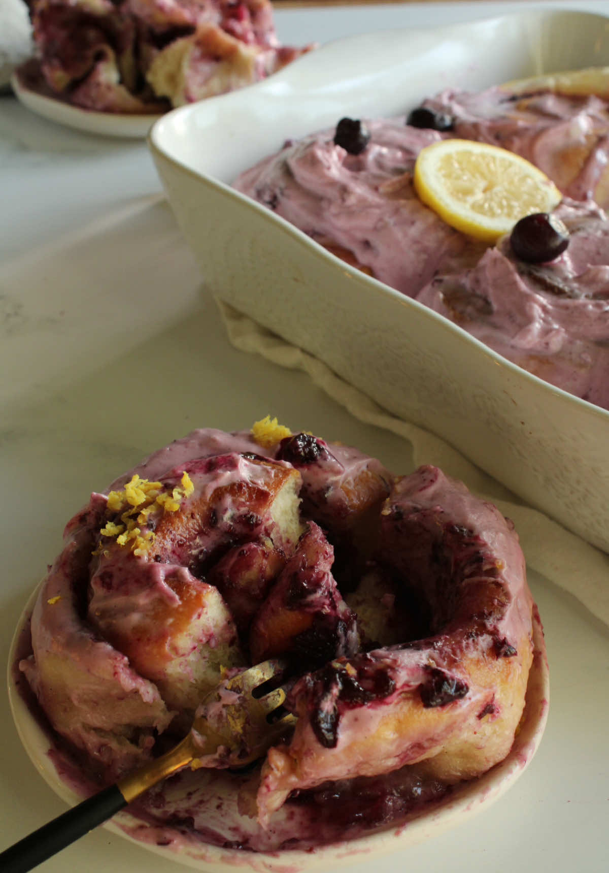 Wow!!! these blueberry rolls 🫐 🍋with lemon-flavored frosting are delicious and perfect for this season. Ingredients FOR THE DOUGH 650 g flour 430 ml milk 70 g sugar 11 g salt 108 g sourdough starter 2 egg yolks 80 g butter 2 tablespoons vanilla paste 1 teaspoon cinnamon 1 grated lemon peel (optional) FOR THE FILLING  170 g blueberry jam 150 g butter 80 g sugar FOR THE BLUEBERRY JAM  200 g blueberry jam 65 g sugar Juice of half a lemon 1 slice of lemon peel (you can remove it at the end, but it helps make the consistency thicker) FOR THE ICING Six ounces of Philadelphia cream Juice of half a lemon 1/3 cup butter 1 cup powdered sugar 1 teaspoon vanilla extract 2 tablespoons blueberry jam Steps  1. Mix all the ingredients except the butter and let it rest for 20 minutes. 2. Continue kneading the dough (by hand or machine). Once it looks smooth, start adding the butter little by little. 3. Once the butter is well incorporated, place the dough in a container and cover it to prevent it from drying out. 4. Let the dough ferment at room temperature until it rises 50-60% of its initial size (approximately 6 hours). 5. Once the dough is ready and well fermented, start preparing the jam. 6. In a pot, bring all the jam ingredients to a boil and mash the blueberries with a fork until you have a thicker consistency. Let it cool. 7. In a separate bowl, mix the jam you made with the butter and sugar. 8. Roll out the dough very well and place your mixture on top so you can roll it up. 9. Cut the rolls to the size you want and place them in a mold.  10. Let the rolls rise for three to four hours. 11. Once they're ready, place them in the oven for 25-30 minutes at 320°F. 12. Once your cinnamon rolls are ready, let them cool, add the frosting, and enjoy. #CapCut #blueberryrolls #cinnamonroll #sourdough #bakingathome #recipes #cinnamonrollsrecipe #fyp #creatorsearchinsights #cookingathome 