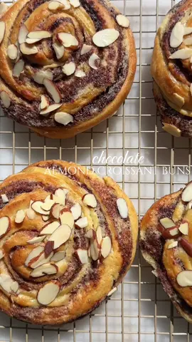 chocolate almond croissant buns 🥐  INGREDIENTS  Brioche Dough  7 g instant yeast  30 g warm milk (90 F)  30 g granulated sugar  250 g bread flour  3 large eggs  145 g softened unsalted butter 1/2 tsp kosher salt  1/2 tsp vanilla paste  1/4 tsp almond extract  Almond Frangipan  56 g softened butter  65 g granulated sugar  1 tbsp orange zest  1/2 tsp vanilla paste  1/2 tsp almond extract  65 g almond flour  1/4 tsp salt Chocolate Filling 35 g dark chocolate bar  30 g butter  15 g powdered sugar  10 g cocoa powder  INSTRUCTIONS  1. Add sugar, yeast, and warm milk to stand mixer bowl and stir until combined. Add bread flour and salt. Add one egg at a time running mixer on low until dough starts to come together. Add in a few cubes of butter at a time and then knead at medium speed for 15-20 minutes until dough is smooth and tacky. 2. Place dough in a lightly oiled bowl and cover until doubled in size. 3. Prepare chocolate filling by melting chocolate bar and butter over a double broiler. Remove from heat and mix in cocoa powder and powdered sugar. Set aside until mixture has set.  4. Prepare almond frangipan filling by rubbing orange zest and sugar together. Add in butter and mix until light and fluffy. Add in vanilla paste, almond extract, eggs, and salt and whisk. Fold in almond flour until smooth.  5. Roll out dough in floured surface until you form a rectangle. Evenly spread frangipan and chocolate filling on 2/3 of the dough. Fold in 1/3 of the dough inwards, and then the other side - similar to folding a letter.  6. Roll out slightly with a rolling pin, then cut lengthwise with a pizza roller to create 6-8 strips.  7. Roll up strips tucking ends underneath. Place on a parchment lined baking sheet and cover loosely until doubled in size. 8. Brush with egg wash and sprinkle with sliced almonds. 9. Bake at 350 degrees F for 20-22 or until internal temperature is 190 F.  10. Allow to cool completely then sprinkle with powdered sugar.  #baketok #baker #Recipe #chocolate #bakingtips #baking #almondcroissant #cinnamonroll #buns #almonds #dessert #asmr #eidmubarak #girltok 