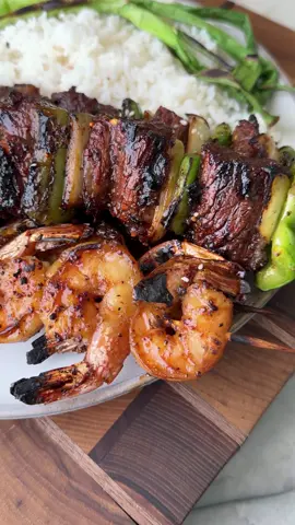 Steak & Shrimp Skewers 🧄Ingredients: Bachan’s Roasted Garlic Japanese BBQ Sauce Ribeye steak Colossal shrimp Salt, garlic powder, & black pepper Yellow onion, green bell pepper, green onions White rice 📝Directions: 1. Cube ribeye into 1.5-inch pieces and marinate in ½ cup Bachan’s Roasted Garlic + salt and pepper for 1 hr. 2. Marinate shrimp separately in ¼ cup Bachan’s Roasted Garlic for 1 hr. 3. Preheat grill for direct high-heat cooking. 4. Slice onion and bell pepper into 2-inch pieces. 5. Assemble steak skewers, alternating with onions & peppers. 6. Grill steak skewers over high heat, turning every 2 minutes until cooked to preference. 7. Grill shrimp skewers & green onions for 2 minutes per side 8. Serve skewers over a bed of white or fried rice, drizzle with more Bachan’s Roasted Garlic, sprinkle sesame seeds & enjoy! @burnt_pellet_bbq