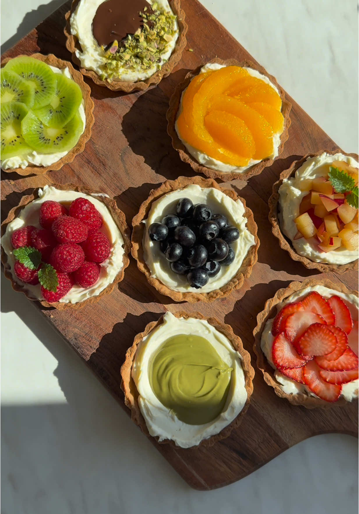 [In English below] Tartaletki wielkanocne.🐣🌸 Składniki na ciasto kruche (na 18–20 tartaletek): 500 g mąki pszennej + trochę do podsypania 100 g cukru pudru 250 g zimnego masła 2 jajka 1 laska wanilii lub 1 łyżeczka pasty waniliowej Składniki na krem i dodatki: 3–4 łyżki cukru pudru (ilość zależna od słodyczy owoców) 500 g mascarpone 1 laska wanilii lub 1 łyżeczka pasty waniliowej Ulubione dodatki: maliny, truskawki, borówki, kiwi, pasta pistacjowa, pomarańcza, śliwka, roztopiona czekolada Przygotowanie: 1. Przygotowanie ciasta kruchego: Przesiej mąkę i cukier puder do dużej miski. Dodaj pokrojone w kostkę zimne masło i rozcieraj palcami (lub zmiksuj w malakserze), aż powstanie kruszonka. W osobnej misce roztrzep jajka z wanilią. Dodaj je do kruszonki i szybko zagnieć całość, aż powstanie jednolite ciasto. Jeśli masa będzie zbyt mokra, dodaj odrobinę mąki. Uformuj kulę, zawiń w folię spożywczą i schłodź w lodówce na czas przygotowania kremu. 2. Przygotowanie kremu: Przesiej cukier puder do miski, dodaj mascarpone i wanilię. Wymieszaj wszystko dokładnie, aż powstanie gładki krem. Ilość cukru możesz dostosować do słodkości wybranych dodatków. 3. Formowanie i pieczenie tartaletek: Rozgrzej piekarnik do 180°C (góra-dół). Na lekko oprószonym mąką blacie rozwałkuj ciasto na grubość 2–3 mm. Wytnij kółka o średnicy o około 1 cm większej niż foremki. Wylep foremki ciastem, nadmiar odetnij. Zgnieć kawałki papieru do pieczenia, rozprostuj je i wyłóż nimi tartaletki. Wsyp do środka groch, ryż lub kulki ceramiczne. Piecz na środkowej półce przez 15 minut. Usuń obciążenie i papier, a następnie dopiecz spody przez kolejne 5 minut, aż będą złociste. Odstaw do wystudzenia. 4. Dekorowanie: Na wystudzone spody wyłóż krem mascarpone, a następnie udekoruj owocami, pastą pistacjową, czekoladą — wedle uznania. Wesołych Świąt!  Easter tartlets.🐣🌸 Ingredients for shortcrust pastry (for 18–20 tartlets): 500 g wheat flour + some for dusting 100 g icing sugar 250 g cold butter 2 eggs 1 vanilla pod or 1 teaspoon vanilla paste Ingredients for the cream and toppings: 3–4 tablespoons icing sugar (the amount depends on the sweetness of the fruit) 500 g mascarpone 1 vanilla pod or 1 teaspoon vanilla paste Favorite toppings: raspberries, strawberries, blueberries, kiwi, pistachio paste, orange, plum, melted chocolate Preparation: 1. Preparation of shortcrust pastry: Sift the flour and icing sugar into a large bowl. Add the diced cold butter and rub with your fingers (or blend in a food processor) until crumbles are formed. In a separate bowl, whisk the eggs and vanilla. Add them to the crumble and quickly knead the whole thing until you have a smooth dough. If the mixture is too wet, add a little flour. Form a ball, wrap in cling film and chill in the fridge while you prepare the cream. 2. Prepare the cream: Sift the icing sugar into a bowl, add the mascarpone and vanilla. Mix everything well until you have a smooth cream. You can adjust the amount of sugar to the sweetness of the selected additions. 3. Forming and baking the tartlets: Preheat the oven to 180°C (top and bottom). On a lightly floured worktop, roll out the dough to a thickness of 2-3 mm. Cut out circles about 1 cm larger in diameter than the tins. Line the tins with the dough, trim off the excess. Crumple the pieces of baking paper, flatten them and line the tartlets with them. Add peas, rice or ceramic balls. Bake on the middle rack for 15 minutes. Remove the weights and paper, then bake the bases for another 5 minutes, until golden brown. Set aside to cool. 4. Decorate: Spread the mascarpone cream over the cooled bases, then decorate with fruit, pistachio paste, chocolate - as desired. Happy Holidays! #EasyRecipes #easter #wielkanoc #bake #ciasta #pieczenie #gotowanie #cooking #chef #