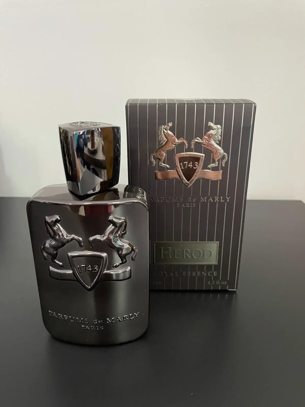 🌟Parfums de Marly Herod🌟 Released in 2012 under the refined banner of Parfums de Marly, Herod is the work of master perfumer Olivier Pescheux—a fragrance that captures the soul of sophistication, draped in spice and wrapped in smoky sweetness. It arrives with quiet confirmed, not demanding attention but effortlessly drawing it in, like a magnetic presence in a dimly lit room. The opening is immediately captivating. A warm dusting of cinnamon mingles with the dry, aromatic crackle of Pepperwood™, setting a tone that is rich, spiced, and slightly mysterious. There’s a distinct firelit aura to it, evoking the image of leather-bound books, slow jazz, and flickering embers in a winter lounge. But Herod doesn’t linger long in its opening. It dives swiftly into a sumptuous heart where tobacco takes center stage—honeyed, smoky, and smooth. Osmanthus lends a soft floral warmth, while cistus and frankincense inject a touch of darkness and resinous depth, like shadows cast by candlelight on old wood. As the fragrance matures, it reveals a lush, addictive base. Vanilla melts through the smoke with a creamy sweetness, never cloying, always refined. Cedarwood and musk offer structure and softness, while earthy cypriol, patchouli, and a hint of vetiver provide a grounding richness that lingers well beyond the drydown. The result is a perfectly balanced composition—masculine leaning, but undeniably elegant and inviting on any skin. In terms of performance, Herod is no slouch. The projection starts off moderate but full-bodied—enough to make an impression without overwhelming the room. As it settles, it becomes more intimate, drawing others closer rather than announcing itself. The sillage follows this same arc: soft, steady trails that never overstay their welcome, yet leave a lasting impression. Longevity is impressive—easily 8 to 10 hours, often more on fabric or in cooler weather—making it a dependable choice for long evenings or all-day wear in the colder months. Herod is not loud, not flashy. It’s smooth, slow-burning luxury in olfactory form. Ideal for formal nights, date settings, or simply when you want to feel wrapped in warmth and quiet power. It doesn’t chase attention—it attracts it, effortlessly. ##HerodByPDM##ParfumsDeMarly##LuxuryFragrance##TobaccoVanilla##SpicyFragrance##NichePerfume##WinterFragrance##OlivierPescheux##WarmAndSpicy##PerfumeReview##FragranceLovers##UnisexPerfume##ElegantScent##FragranceOfTheDay##ScentOfTheNight##PerfumeAddict##CologneGoals##FragranceCommunity##SmellLuxury##PerfumeCollection