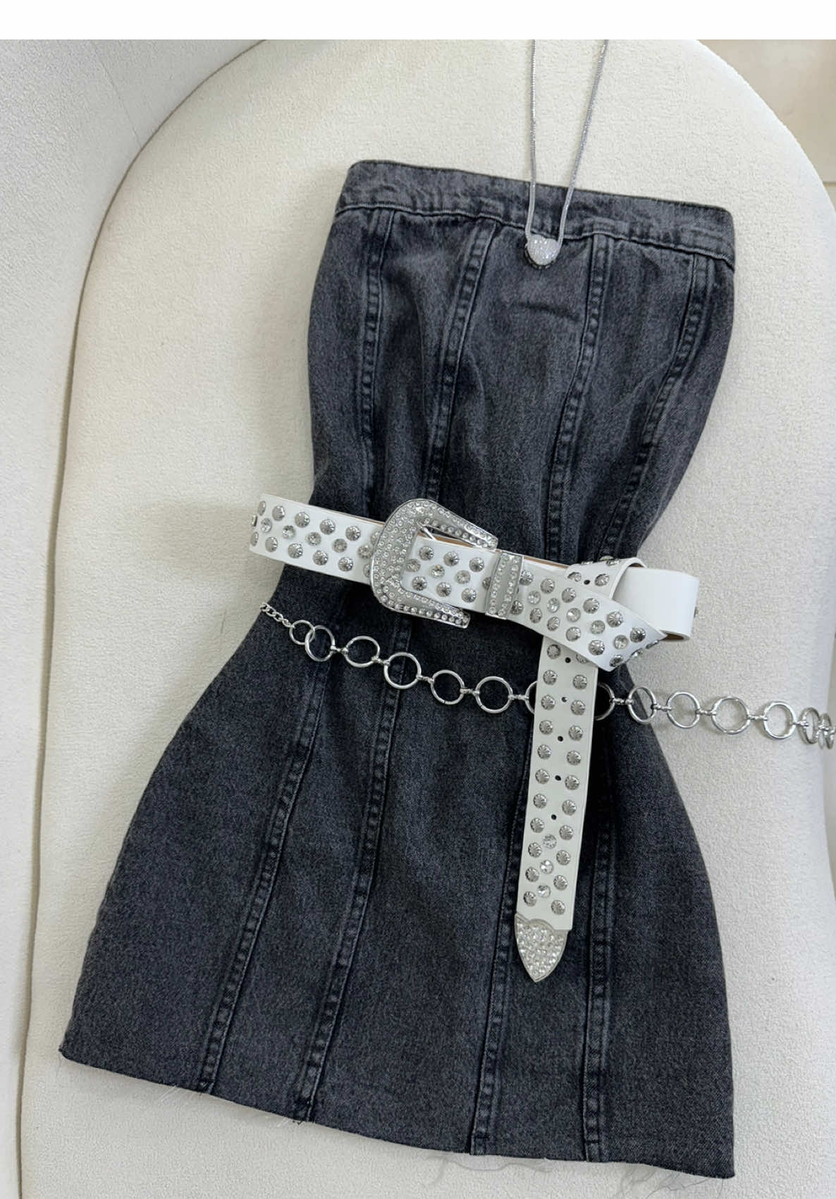 O look que fala por si só! ⚡️🖤 Vestido tomara que caia no jeans estonado com barra desfiada, é o equilíbrio perfeito entre o rústico e o glam! 🥰 E pra dar aquele “up” de estilo: cinto country branco com strass e fivela prata + cinto de corrente prata trazendo atitude, e colar de coração com strass pra dar aquele toque romântico ❤️‍🔥  Disponível na loja física e no site: 🛒 www.alohacamilly.com.br #vestidojeans #lookalljeans #cintobranco #acessórioscountry #modacomestilo #alohacamilly #denimlovers #tomaraquecaia