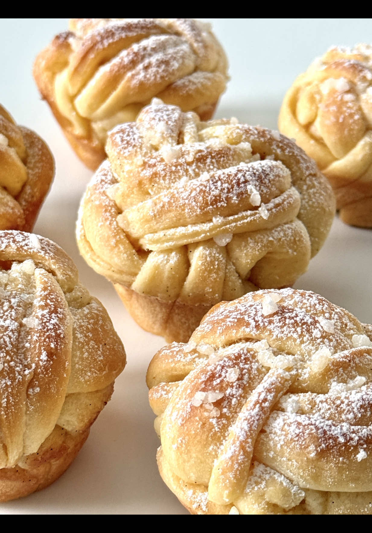 Vanilla Sugar Knots Recipe 🤍 These fluffy vanilla knots are perfect for a cozy afternoon or as a sweet treat for any time of day. Ideal for vanilla lovers! 🥰 📝 Ingredients  For the dough (makes about 10 knots): •	250 g all-purpose flour •	30 g sugar •	1 pinch of salt •	1/2 packet of dry yeast (approx. 3.5 g) •	100 ml lukewarm milk •	30 g soft butter •	1 egg (room temperature)   For the vanilla filling: •	50 g soft butter •	1 tbsp vanilla extract •	30 g sugar (adjust to taste)   For brushing: •	20 g melted butter (for brushing the shaped knots before baking) For topping: •	Pearl sugar 🤍 Instructions: 	 1.	Put the flour into a bowl and create a well in the center. Add the dry yeast, 1 tsp of sugar, and 2–3 tbsp of the lukewarm milk into the well. Stir lightly and let it rest for about 10 minutes until it starts to bubble. 	 2.	Add the remaining milk, sugar, salt, soft butter, and egg. Knead into a smooth dough that pulls away from the sides of the bowl. Cover and let rise in a warm place for about 1 hour or until doubled in size. 	 3.	For the filling, mix the soft butter with  vanilla extract and regular sugar until smooth. 	 4.	Once the dough has risen, roll it out into a large rectangle on a floured surface. Spread the vanilla butter filling evenly over the dough. 	 5.	Fold the dough: bring one side to the center, then fold the other side on top. Cut into even strips. 	 6.	Slice each strip lengthwise into three parts without cutting all the way through. Braid them and twist into knots. 	 7.	Place the knots into a greased muffin tin or on a baking sheet lined with parchment paper. Let rise again for 20–30 minutes. Meanwhile, preheat the oven to 180°C (350°F). 	 8.	Sprinkle with pearl sugar. 	 9.	Bake for 15–18 minutes until lightly golden. Brush the knots with melted butter and let cool slightly before serving. Enjoy! 🤗🤍