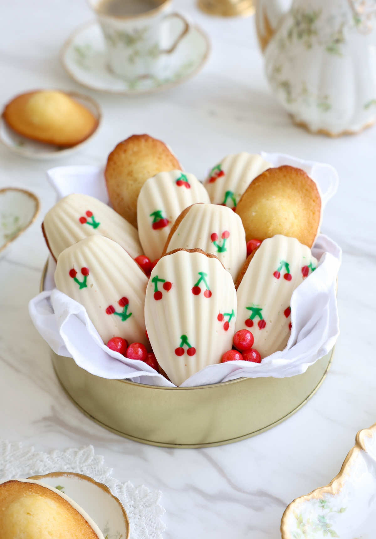 Lemon Madeleines 🍋 Ingredients: •113g unsalted butter, divided •1 tsp lemon or orange zest •100g all-purpose flour •3/4 tsp baking powder •1/4 tsp fine sea salt •2 large eggs, room temp •80g granulated sugar •20g honey •1/8 tsp citrus oil (optional) Method: 1.Melt butter gently. Measure 100g, stir in zest. Chill the rest for greasing the pan. 2.Whisk together flour, baking powder, and salt. 3.Whisk eggs, sugar, and honey until light and slightly thickened. 4.Sift in dry ingredients in 2 additions, then whisk in butter-zest mixture in 3 additions. Stir in citrus oil if using. Fold until smooth. 5.Cover and chill batter at least 4 hours. 6.Brush pan with reserved butter and freeze. 7. Preheat oven to 220°C with a baking sheet inside. Fill molds 3/4 full. 8.Reduce oven to 200°C, and bake 11–12 min. Cool briefly, then unmold. I used tempered white chocolate for the shell and red and green coloring for the cherry. #Recipe 