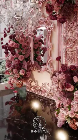A 3D-rendered concept for an intimate akad ceremony—a sacred union wrapped in elegance and romance. Blush and burgundy florals intertwine with rose gold baroque elements, creating a warm, luxurious ambiance for a deeply meaningful moment. Soft crystal chandeliers and black marble reflections set the tone for a timeless atmosphere of love and sincerity. Theme: An intimate akad ceremony with a romantic and refined classical aesthetic. Color Palette: 	•	Blush pink 	•	Burgundy 	•	Rose gold accents 	•	Soft white highlights Key Design Elements: 	•	Backdrop: Rose gold baroque-style frame with integrated floral arrangements and mirrors symbolizing reflection and purity 	•	Akad Table: Sleek black marble surface decorated with soft floral runners and subtle candles 	•	Floral Composition: A curated mix of roses, peonies, and hydrangeas in layered shades of blush and burgundy 	•	Lighting: Crystal chandeliers for soft, ambient light and elegant sparkle 	•	Guest Seating: Draped white chairs tied with minimalistic fabric knots, spaced intentionally to keep the setting personal and serene 	•	Flooring: Glossy black marble to enhance reflections and add depth to the space Atmosphere & Mood: Serene, sacred, and intimate—perfect for a deeply personal akad moment wrapped in love and understated grandeur. #ronitadesign #3d #3dart #3drender #3danimation #weddingdesigner #weddinginspiration #weddingdesign #dekor #weddingdecor #weddingstyle #weddingdecoration #arsitek #architect