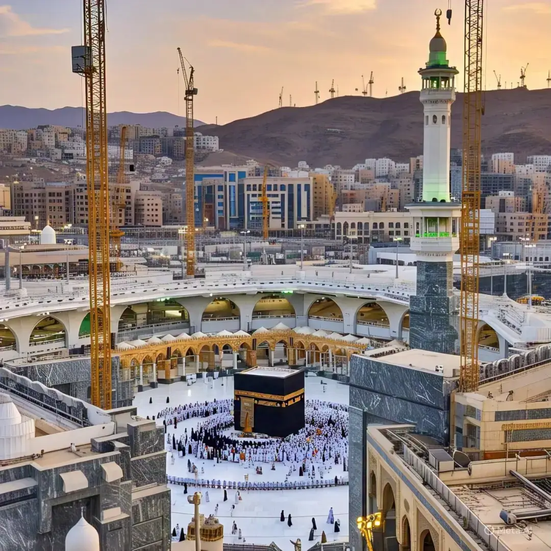 The image you shared is a stunning depiction of the Kaaba in Masjid al-Haram, Mecca, with worshippers walking around it during what appears to be either sunrise or sunset. The scene is framed with palm trees and flowers, adding a peaceful and spiritual vibe to the moment.