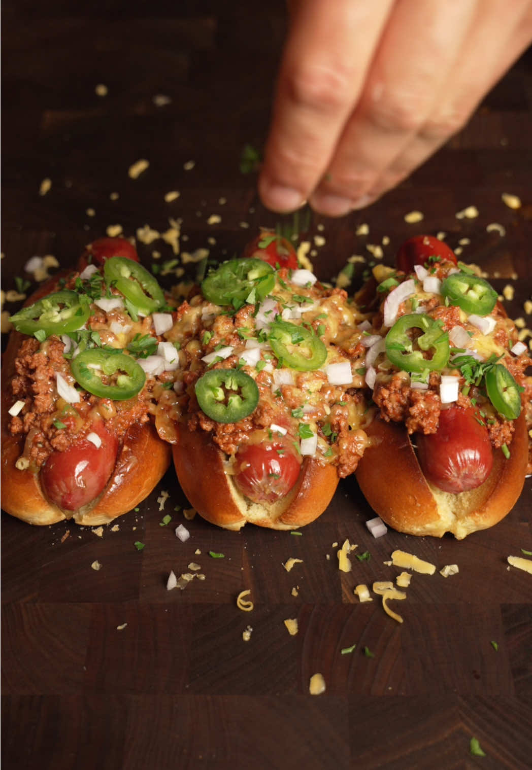 Chili Dogs 🌭  INGREDIENTS  * 6 Hot Dog Buns * 6 Hot Dogs * Cheddar cheese  Homemade chili  * 1 lb. ground beef 80/20 * 1 onion finely diced * 1 green bell pepper * 2 cloves of garlic minced  * 1/2 cup beef stock  * 1 can Tomato Sauce * 1/4 cup Ketchup * 1 tsp onion powder * 1 tsp garlic powder * 2 tsp brown sugar  * 1 tbsp chili powder * 1 tbsp Worcestershire sauce * 1 tsp salt * ½ tsp black pepper Garnish * Chopped Red Onions * Chopped Parsley * Sliced Jalapeños  #chili #hotdog 