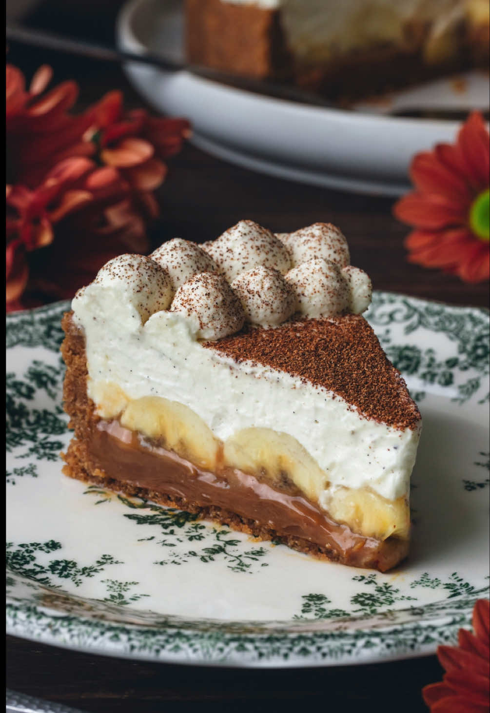Se você ainda está buscando uma inspiração de receita para o Dia das Mães, essa Torta Banoffee é uma ótima opção ♥️  Linda, deliciosa e muito fácil de preparar, essa torta é garantia de sucesso em qualquer ocasião. Aqui utilizei um biscoito com toque de especiarias, que elevou ainda mais o sabor dessa sobremesa. Importante utilizar um doce de leite de boa qualidade, para um resultado ainda mais especial! ✨ Espero que gostem da receita! Se fizer, me conta o que achou? Ingredientes: - 250g de biscoito caramelizado com especiarias (ou outro de sua preferência - como tipo maizena, maltado. Nesse caso, adicione 1 co. chá de canela na mistura) - 130g de manteiga  - 1 pitada de sal - 400g de doce de leite pastoso - 1/4 co. chá de sal - Aprox. 3 a 4 bananas caturra / nanica - Suco de 1/2 limão  - 500g de nata ou creme de leite fresco, bem gelado - 2 co. sopa de açúcar de confeiteiro ou refinado - 1 co. chá de extrato ou pasta de baunilha - Canela em pó, a gosto Em um processador, triture os biscoitos até formarem uma farofa fina. Junte a manteiga derretida, o sal e misture bem. Transfira para uma forma de fundo removível cobrindo todo o fundo e laterais (usei uma de 20cm), pressionando bem. Leve para assar em forno pré-aquecido a 170°C por 10 min. Depois retire do forno e deixe esfriar. Misture o sal (1/4 co. chá) no doce de leite e espalhe sobre a base de biscoito já fria. Corte as bananas ao meio, no sentido longitudinal. Esprema o limão sobre elas para que não escureçam.  Distribua as fatias de banana sobre o doce de leite, preenchendo todos os espaços. Em uma batedeira adicione a nata ou creme de leite fresco, a baunilha e o açúcar. Bata até atingir ponto de chantilly firme (cuidado nessa etapa pois se bater em excesso pode separar e talhar!). Espalhe o chantilly sobre a torta (se quiser fazer uma decoração como eu, reserve parte desse creme para confeitar a torta depois!) e leve à geladeira por 2 horas. Na hora de servir, polvilhe a canela em pó sobre o chantilly (também pode ser cacau ou chocolate em pó). #banoffee #banoffeepie #tortas #fyp #baking #receitas #confeitaria #receitasdoces #bakingtiktok #banana 