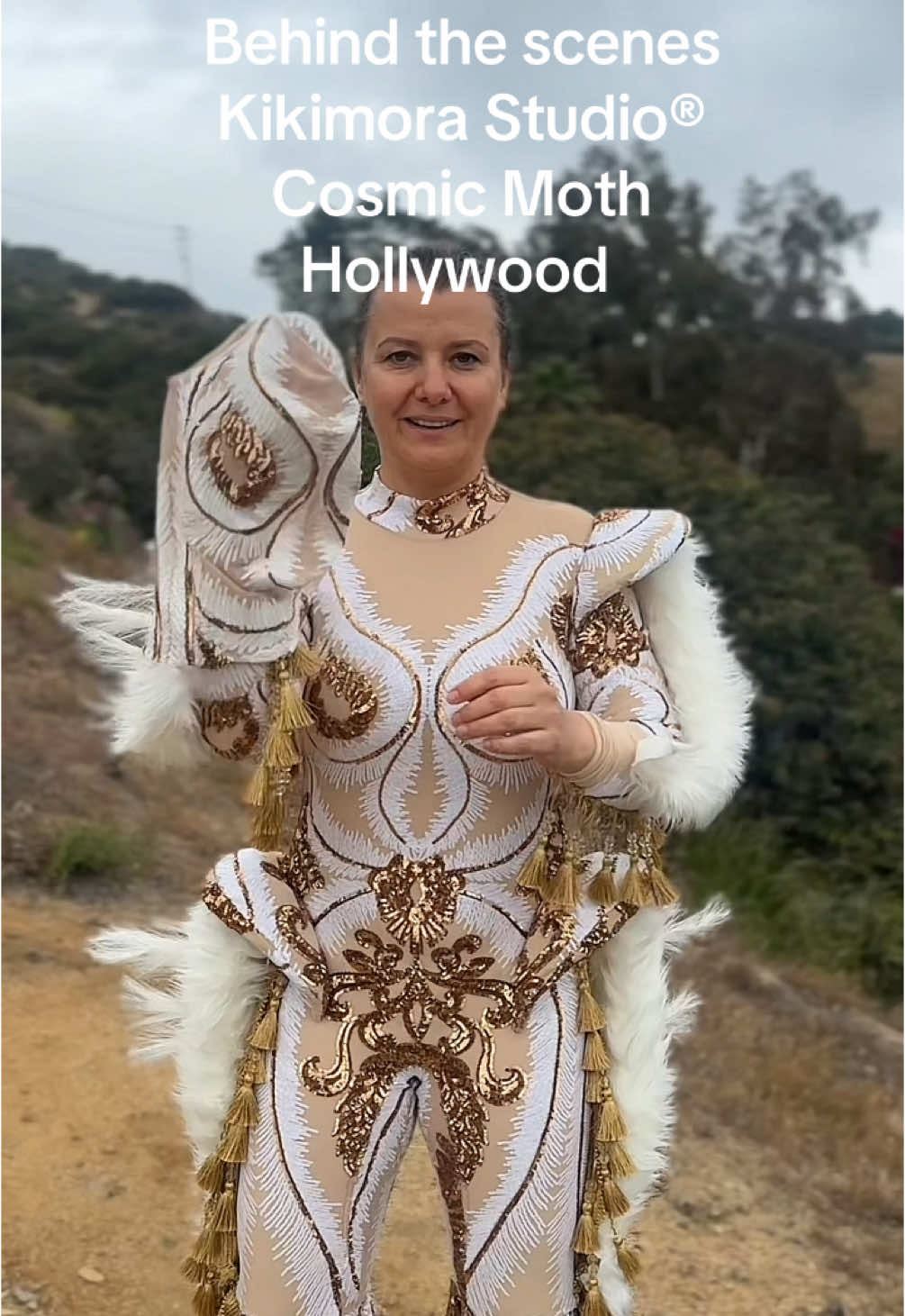 What if a guardian descended from the stars… dressed in gold and silence? Meet the Gilded Guardian, also known as Cosmic Moth—a celestial protector woven from light, velvet, and dreams. Behind the scenes of this otherworldly creation, where every sequin catches the light of a thousand moons, we reveal the quiet power of transformation. This isn’t just a costume—it’s a metamorphosis. A symbol of resilience, cosmic beauty, and unseen strength. Watch her wings unfold. #CosmicMoth #GildedGuardian #CelestialBeing #BehindTheScenes #LivingArt #KikimoraStudio #CostumeDesign #Metamorphosis #PerformanceArt #MothToTheFlame #GoldenGlow #FantasyFashion #AvantGardeStyle #TikTokArt Behind the scenes Kikimora Studio® Cosmic Moth character photoshoot at Hollywood hills.