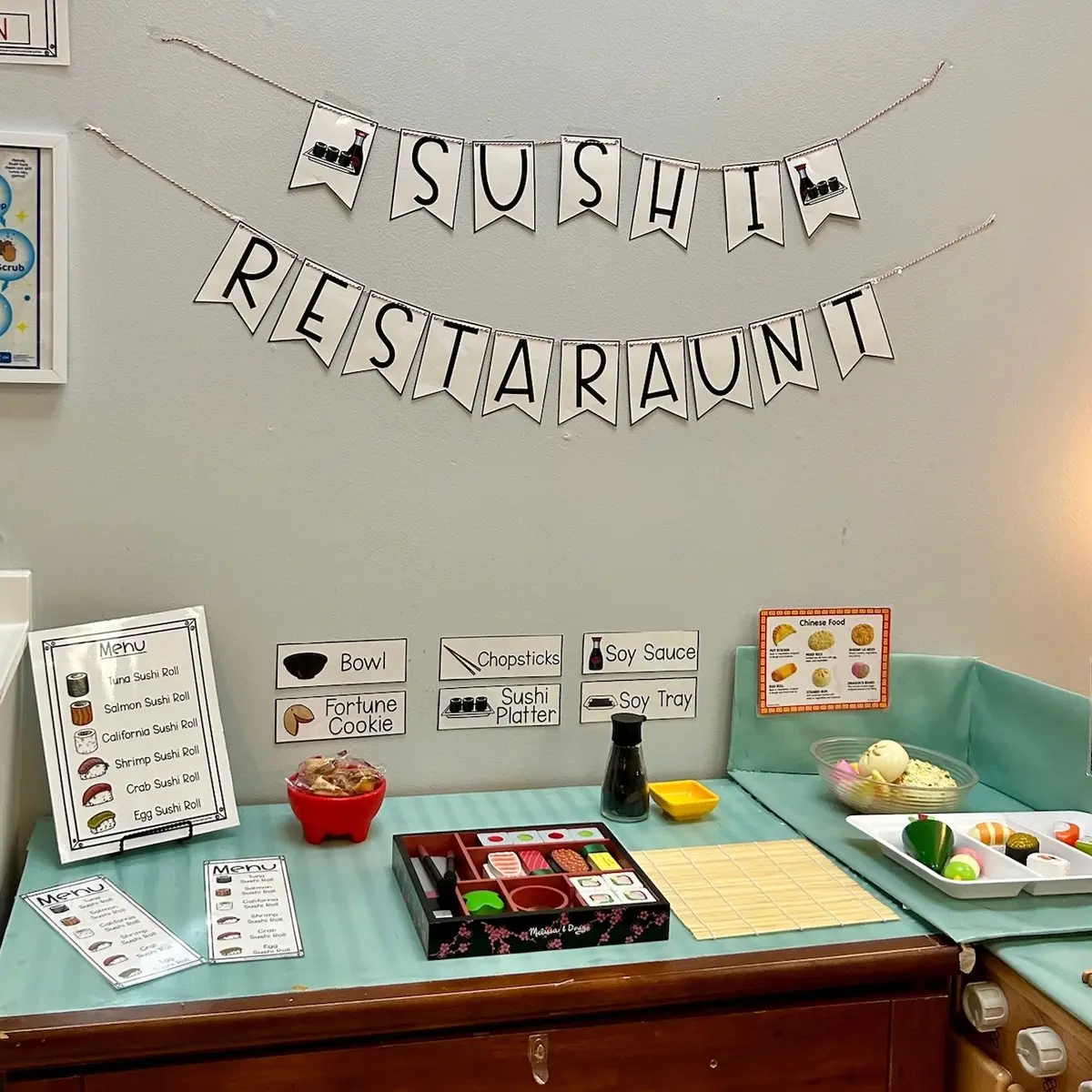 Welcome to our Sushi Restaurant! This dramatic play setup invites children to step into the role of chef, server, and customer as they explore practical life skills, language development, and cultural appreciation through hands-on learning. We’re using the beautifully crafted @Melissa & Doug sushi set, complete with chopsticks, soy sauce, and a variety of sushi rolls that inspire creativity and fine motor practice. Our little ones love taking orders with real menus, preparing platters, and finishing each meal with a fortune cookie surprise! This sort of purposeful play encourages independence, collaboration, and joyful exploration.  #woodentoys #melissaanddoug #montessori #learnthroughplay #playbasedlearning #preschoolteacher #preschoolactivities #toddleractivities #montessorimom
