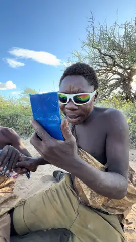 Hadzabe Tribe bushmen see new things for the first time, they are using a mirror and hair comb and sunglasses for the first time