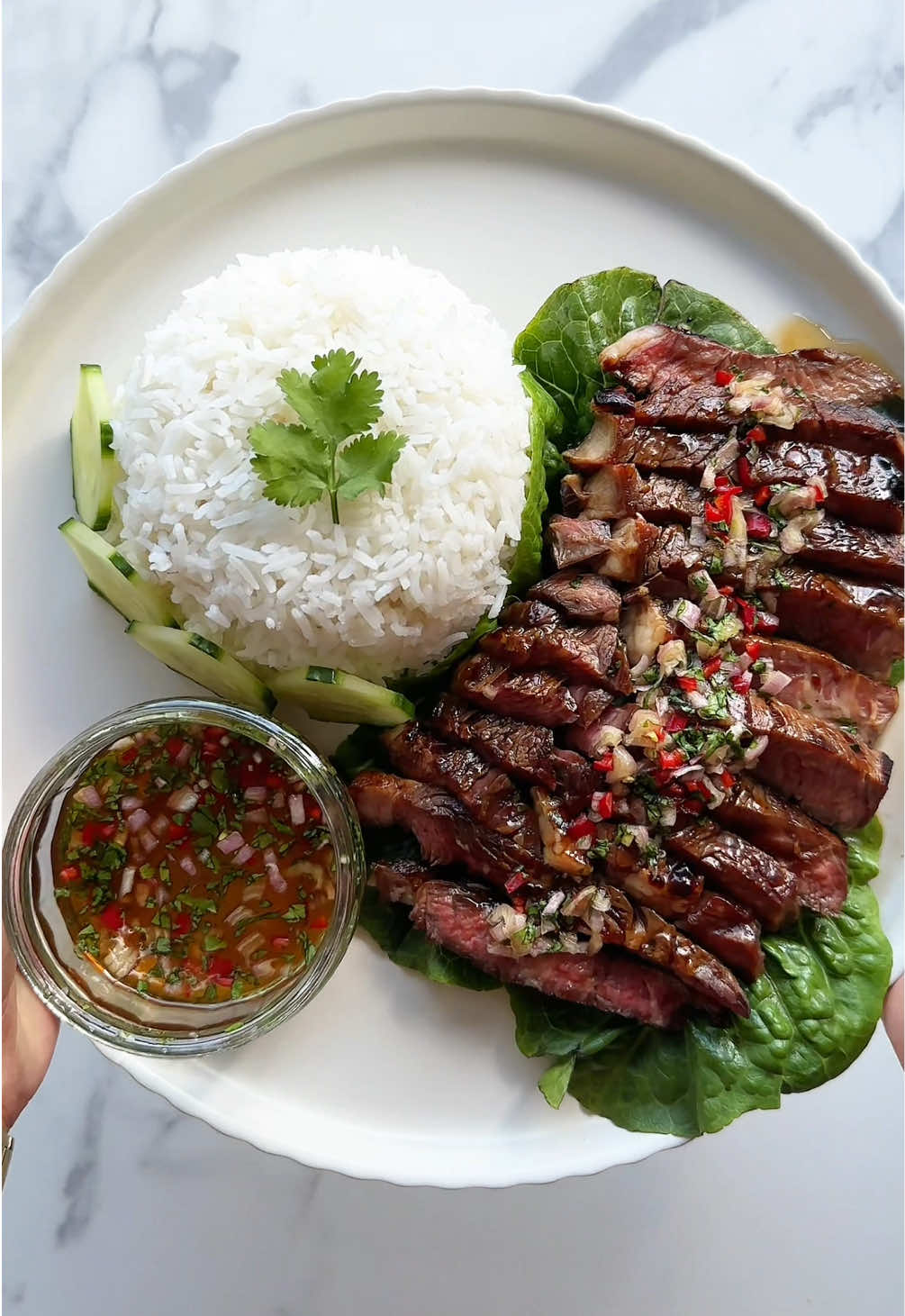 Don’t sleep on Crying Tiger Steak! 😭🐯🥩 Genuinely one of the most flavoursome dishes, tewwww good 🤤 literally only takes 30 mins to make as well!  Recipe: -Season your ribeye with salt and pepper, then coat it in a marinade made of 2 tbsp oyster sauce, 2 tbsp fish sauce, 2 minced garlic cloves, and 2 tbsp honey. -Create your nam jim jaew dipping sauce by combining 3 tbsp fish sauce, the juice of 1/2 a lime, 2 tbsp honey, 1 tbsp chili flakes, 1/2 a thinly sliced shallot, and a handful of chopped coriander. -Put rice on to cook and heat up the pan you’ll be using for your steak -Cook your steak on high, I do 1.5 minutes per side if it’s not very thick, but adjust based on the thickness of your steak and how you like it cooked. -Feel free to pour some of the sauce over your steak or leave it on the side for dipping! #cryingtiger #cryingtigerbeef #steakrecipe #highprotein #healthyrecipes #EasyRecipe #fyp 