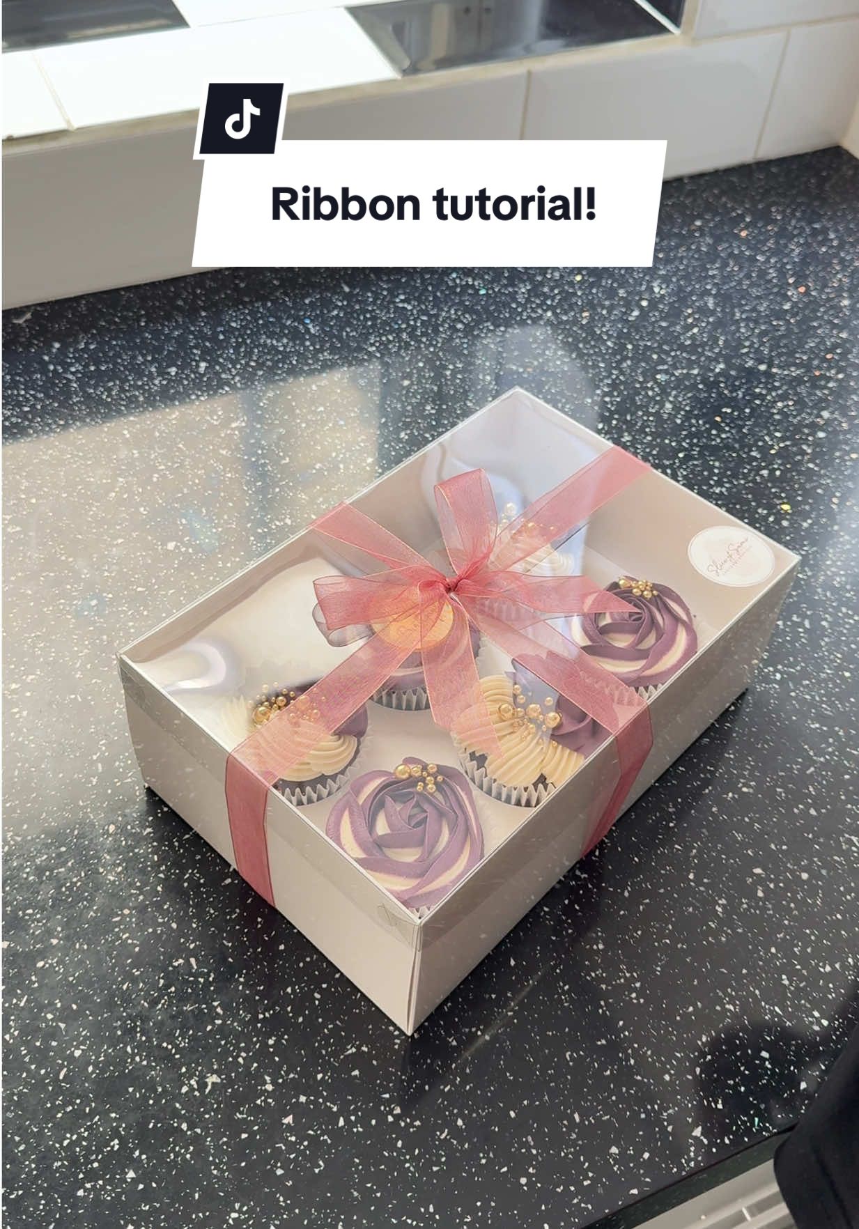 How to tie a ribbon around your cupcakes box / gifts in general 🥰💜 #howtotiktok #tutorial #howtotieribbon #ribbon #ribbontutorial #piping #pipingbuttercream #pipingvideo #pipingcupcakes #cupcakedecorating #cupcakedecoratingvideo #cake #caketok #caketiktok #buttercreamcupcakes #cakedecorating #cakedecoratingvideos #cakedecorator #cakedecoratingtutorial #cakeideas #cakeinspo #cakedesign #caketutorial #processvideo #cakesoftiktok #SmallBusiness  #fyp ✨