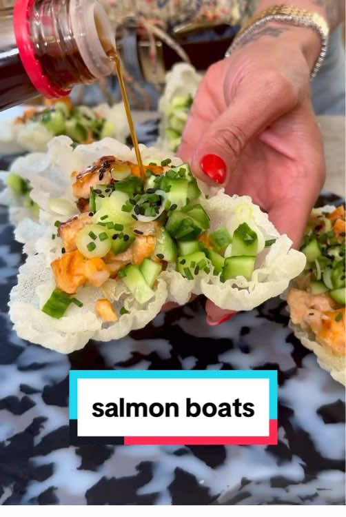 BAKED SALMON CRUNCHY RICE PAPER BOATS! - I took my viral baked salmon sushi cups and turned them into these little boats and they turned out so so good-the perfect easy and delicious dinner!! These are also fantastic to serve at a get together/party since the crunchy rice paper boats are sturdy and don't get soggy! SO FUN TO EAT! Makes 4 servings SALMON 11/2 los salmon, skin removed and cubed 3 to soy sauce or coconut aminos 3 to kewpie mayo 2 tb rice vinegar 1 tb avocado oil 1 tb sriracha CUCUMBER SALAD 3 persian cucumbers, chopped 3 green onions, chopped 2 tsp rice vinegar 12 rice paper wraps, quartered 1 cup avocado oil 1/4 cup ponzu sauce (optional) Garnish: black sesame seeds Turn your broiler on high. Add the cubed salmon, soy sauce, mayo, vinegar, oil and sriracha to a bowl. Mix and coat everything well. Transfer to a baking sheet in an even layer. Broil for 8-9 minutes until browned on top. Remove from oven and set aside. To make the cucumber salad, chop the cucumbers and green onions and toss with rice vinegar. Set aside. Next, cut the rice paper into quarters. Add the avocado oil to a large skillet over high heat. You need to wait for the oil to get extremely HOT before adding the rice paper; approximately 5 minutes. You can test the heat by dropping one of the rice paper sheets in the oil. When it is hot enough, the rice paper will shrivel up as shown in the video! If it doesn't, wait a few minutes longer. Once you are ready take two quarters of the rice paper and stack on top of the other and drop in the oil —the two layers will make these sturdy! Place in the oil and immediately pull them out once they crisp up. Repeat until your rice paper is done. Let cool then fill with baked salmon, cucumber salad, and a drizzle of ponzu sauce (if using). Garnish with sesame seeds if desired and ENJOY! #bakedsalmon #salmon #salmonrecipes #cucumbersalad #foodtrends #viralrecipes