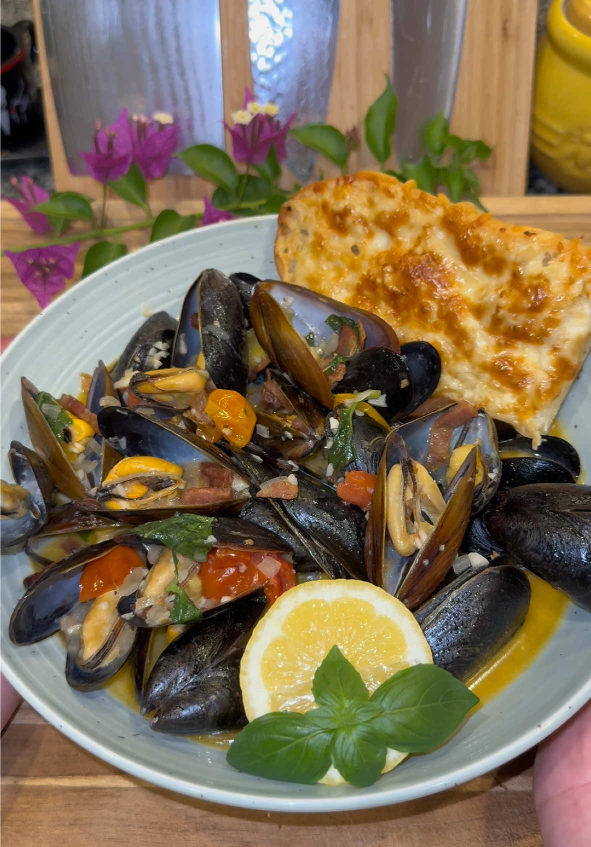 Tomato Basil Mussels🍅🌿 #Recipe #mussels #seafood #Summer #DinnerIdeas #foodtiktok #EasyRecipe  Start out by slicing up a half pound of Pancetta, Guanciale, or Bacon.   Cook it in a large pan on medium heat until it’s nice and crispy, then set aside.  Remove some oil from the pan (leaving about 3 tablespoons worth)  Then add: -1 large minced shallot -2 tablespoons of minced garlic  -red pepper flakes (to taste) -1 cup of dry white wine  -1 cup of chicken broth  -1/4 cup of heavy whipping cream  -4 tablespoons of butter -chicken bouillon powder and salt & pepper to taste -1.5 cups of sliced cherry tomatoes Then add around 2 pounds of mussels that have been scrubbed clean, (make sure to throw out any that were open prior to cooking.)  Then lightly toss this all together and cook covered for about  5 to 7 minutes, (or until all the mussels open.) Take off the heat, and add in: -the juice from 1 lemon -your crispy Guanciale, Bacon or Pancetta -a generous amount of fresh basil Serve this right away with the broth and some bread to dip into it.  Enjoy💜