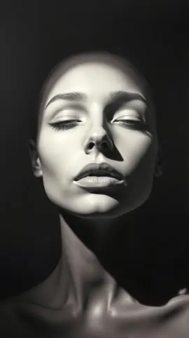 A dramatic black and white close-up portrait of a woman with her eyes closed, strong light and shadow sculpting her serene face, evoking calm and introspection.  #BlackAndWhite #Portrait #Shadows