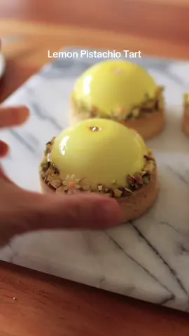 🍋 Lemon Pistachio Mousse Tart A refreshing lemon mousse paired with a crisp tart shell, fluffy vanilla sponge, and rich pistachio ganache. Perfect for spring & summer! 🟡 Vanilla Sponge Egg yolks 40g (2 yolks) Honey 15g Egg whites 70g (2 whites) Salt a pinch Sugar 35g Cake flour 30g Canola oil 12g Vanilla extract 3g Bake at 375°F (190°C) for 8–9 min  🍋 Lemon Mousse Lemon juice 50g Sugar 55g Lemon zest (1 lemon) Egg 50g Egg yolk 20g Gelatin 1.5 sheets (3g) Unsalted butter 35g Heavy cream 35% 170g Fills 6 cavities of Silikomart SF002 mold 🥧 Tart Shell Unsalted butter 125g Powdered sugar 60g Egg 25g (half an egg) Vanilla extract 3g All-purpose flour 190g Bake at 350°F (175°C) for 14–15 min ✔️ Used 8cm tart rings ✔️ Time may vary depending on your oven & dough thickness 🟢 Pistachio Ganache White chocolate 70g (Callebaut W2) Heavy cream 35% 28g Pistachio paste 100% 14g Use about 18g per tart 🟨 Glaze Water 30g Sugar 90g Glucose syrup 90g (or corn syrup) Heavy cream 35% 60g Gelatin sheets 4 (8g total) White chocolate 90g 🎥 Full recipe & tutorial on my YouTube channel. Link in bio☺️ #pastry #pastryart #tart #lemontarts #lemonpistachiocake #dessert #homebaking #pistachiotart #pastrylove